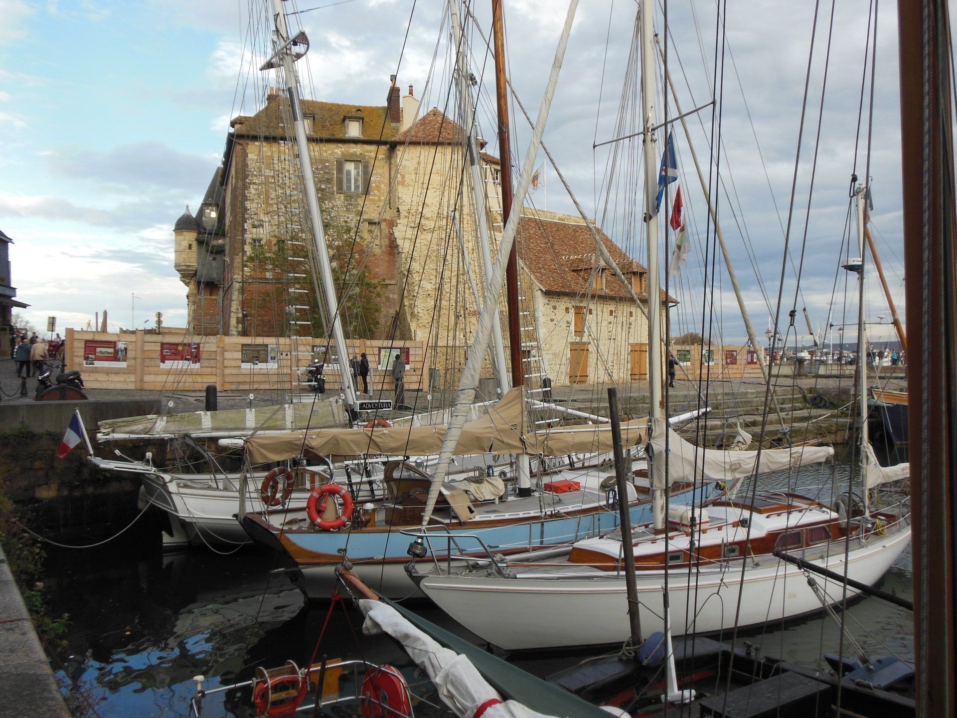 Boats are docked in a harbor with a building in the background