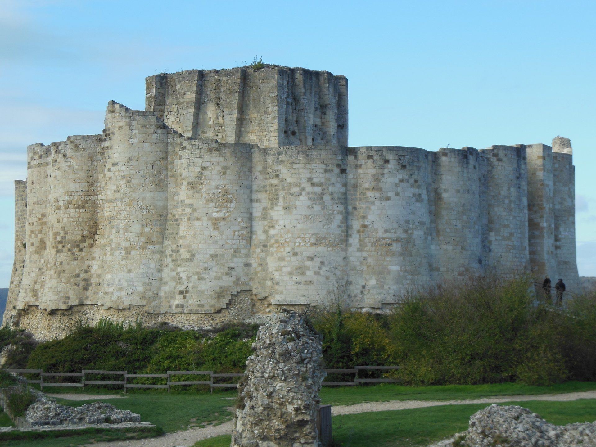 A large stone castle with a blue sky in the background