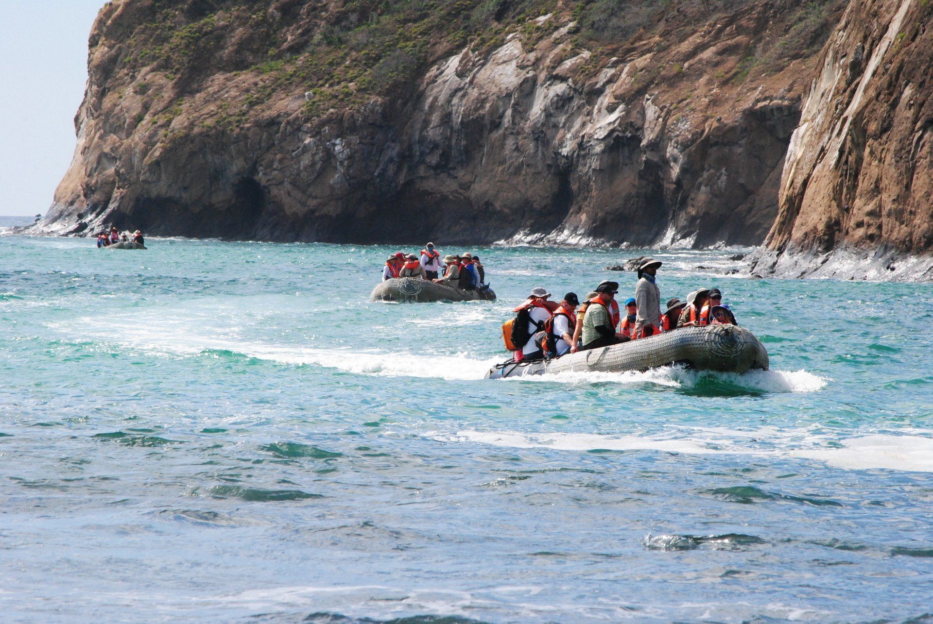 A group of people are riding rafts in the ocean.