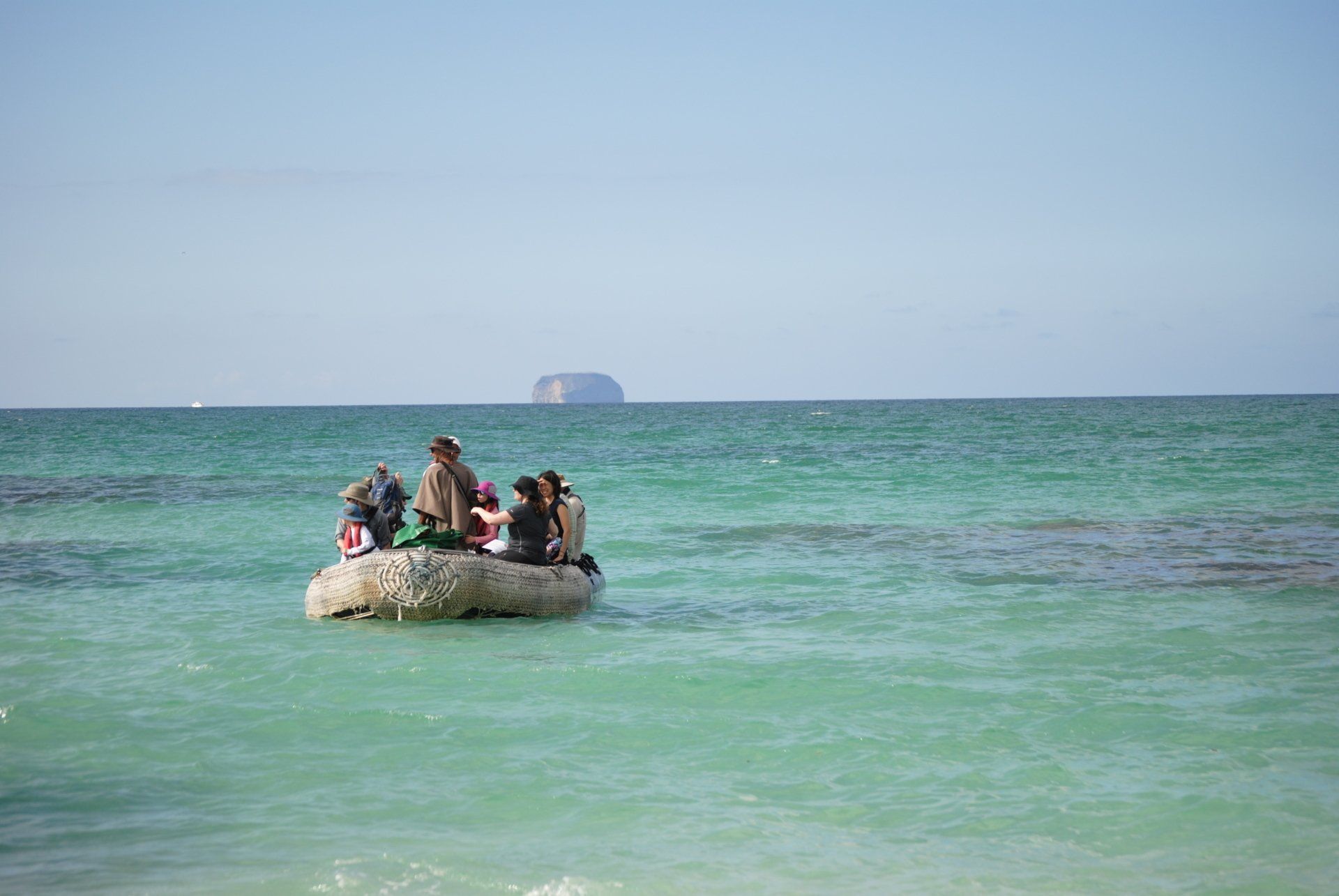 A group of people are in a boat in the ocean.