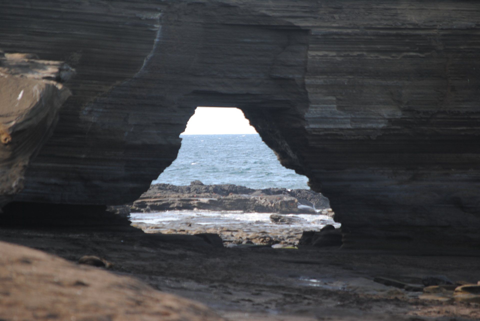 A view of the ocean through a hole in the rocks