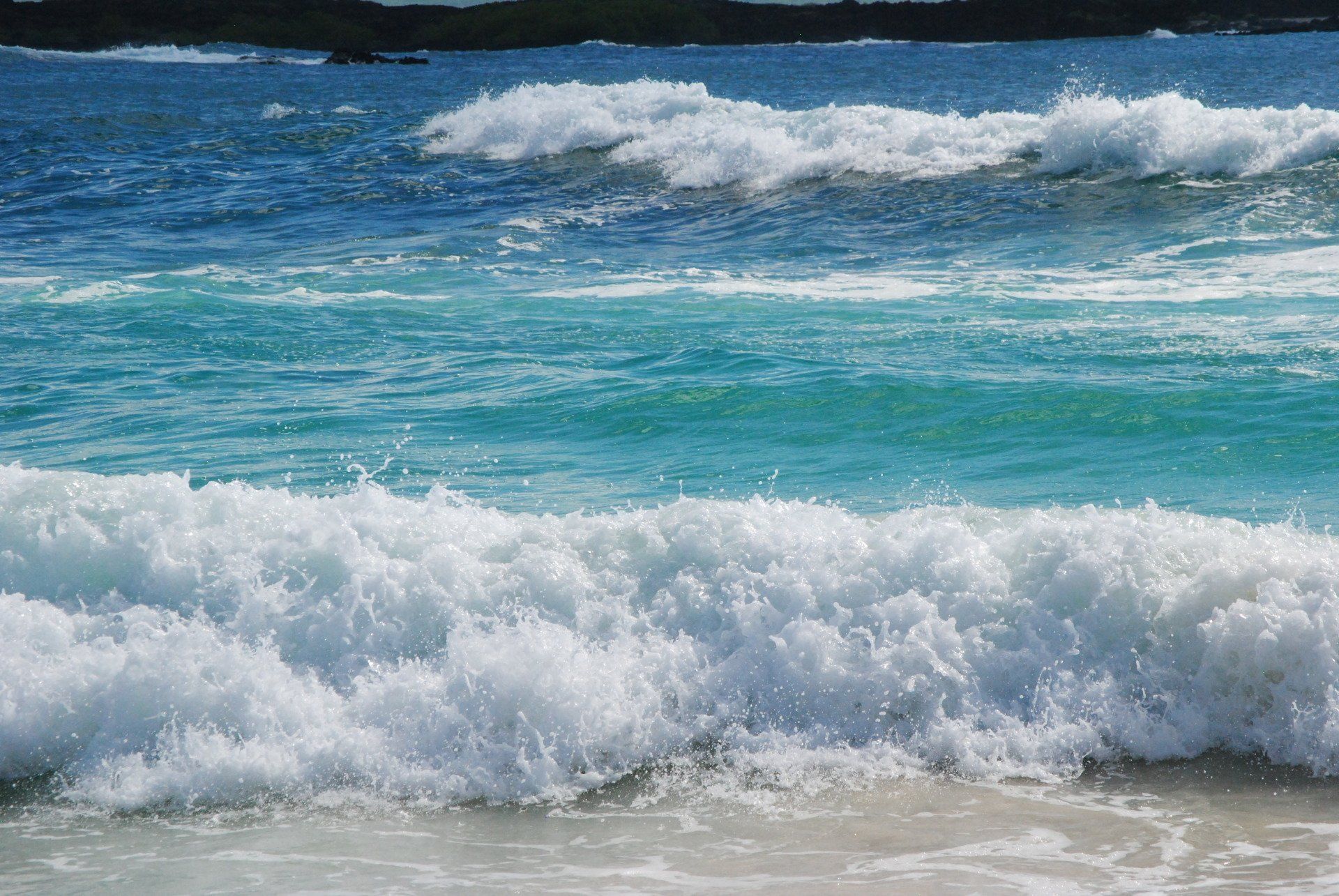 A close up of a beach with waves crashing on the sand