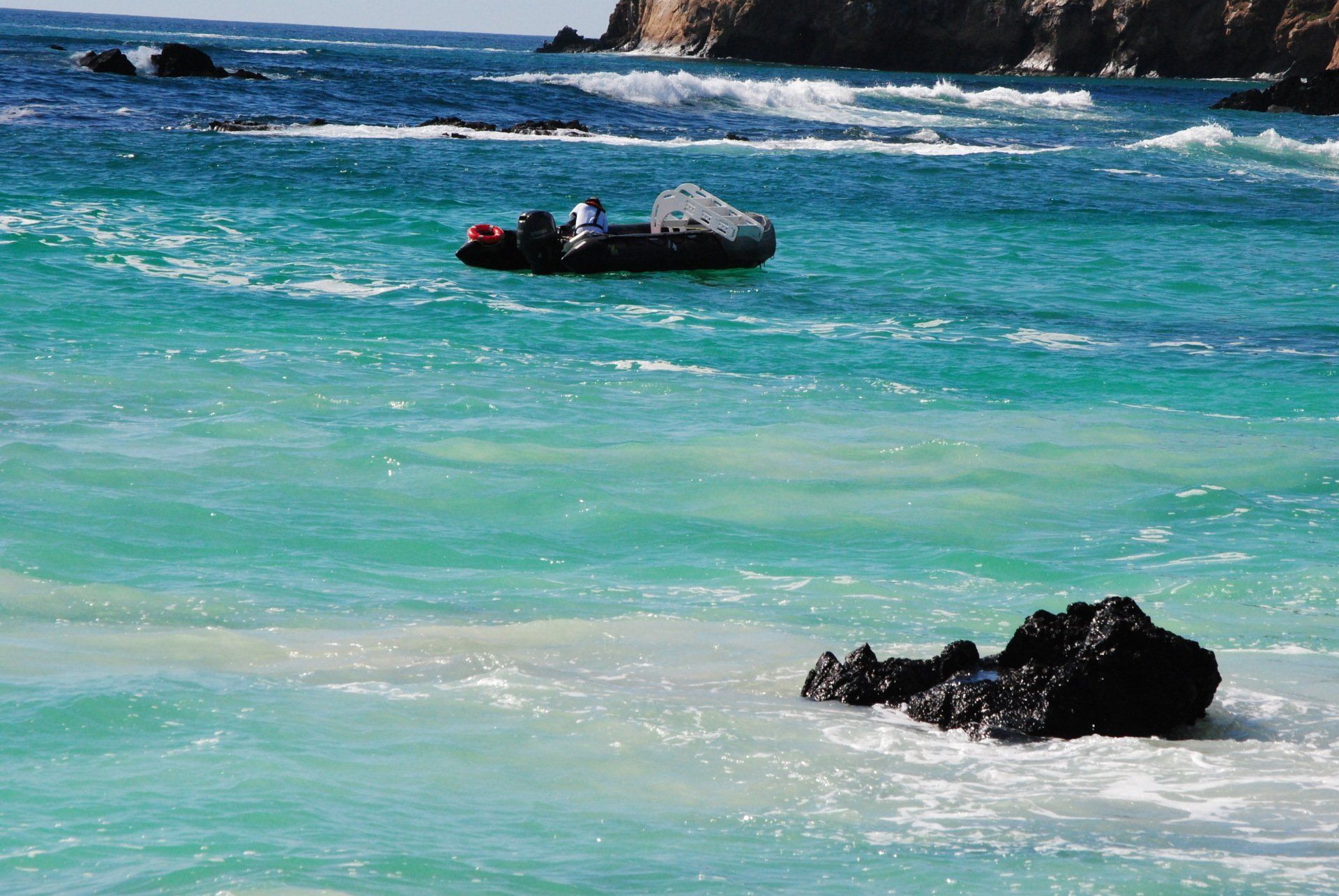 A boat is floating on top of a large body of water.