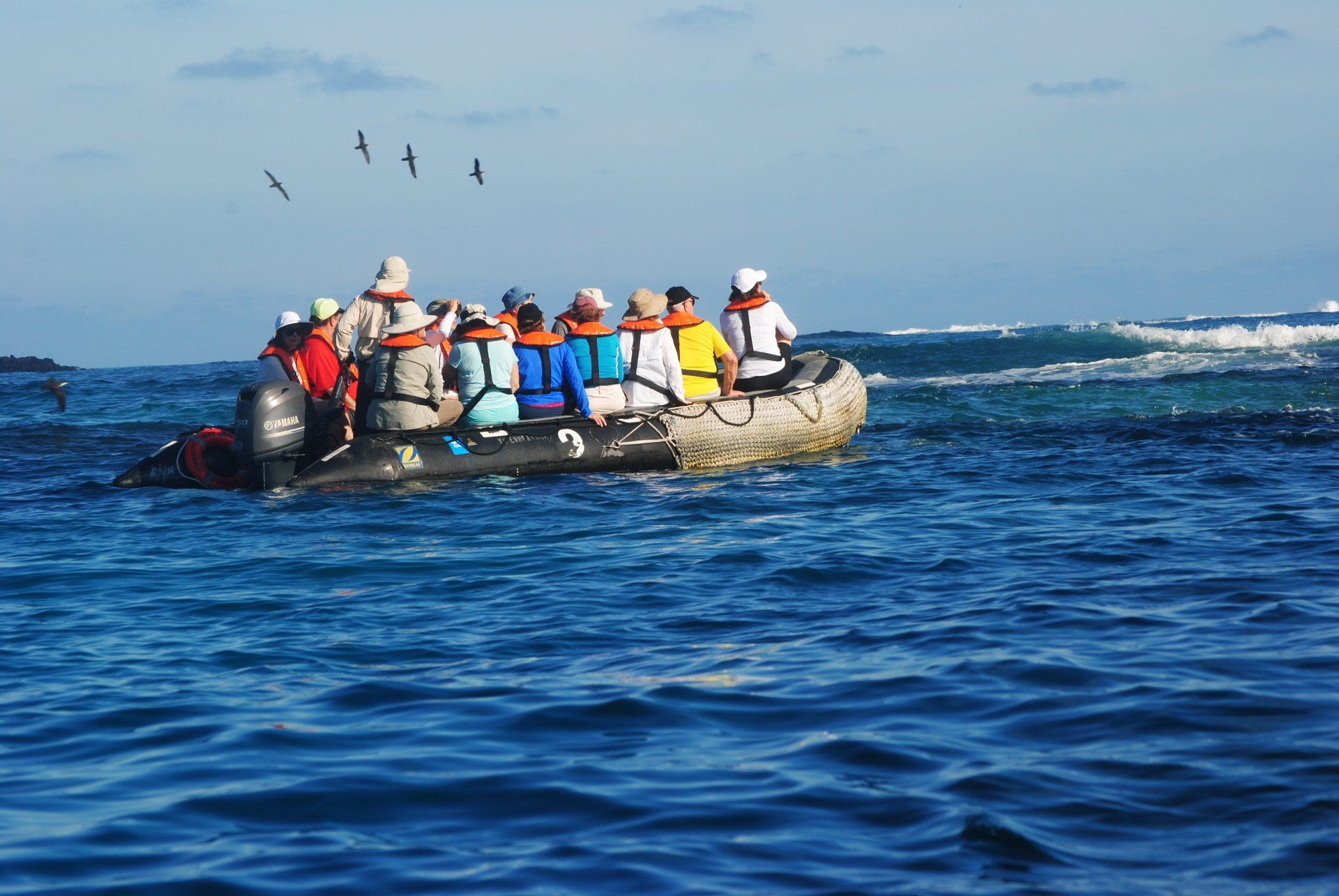 A group of people are in a boat in the ocean.