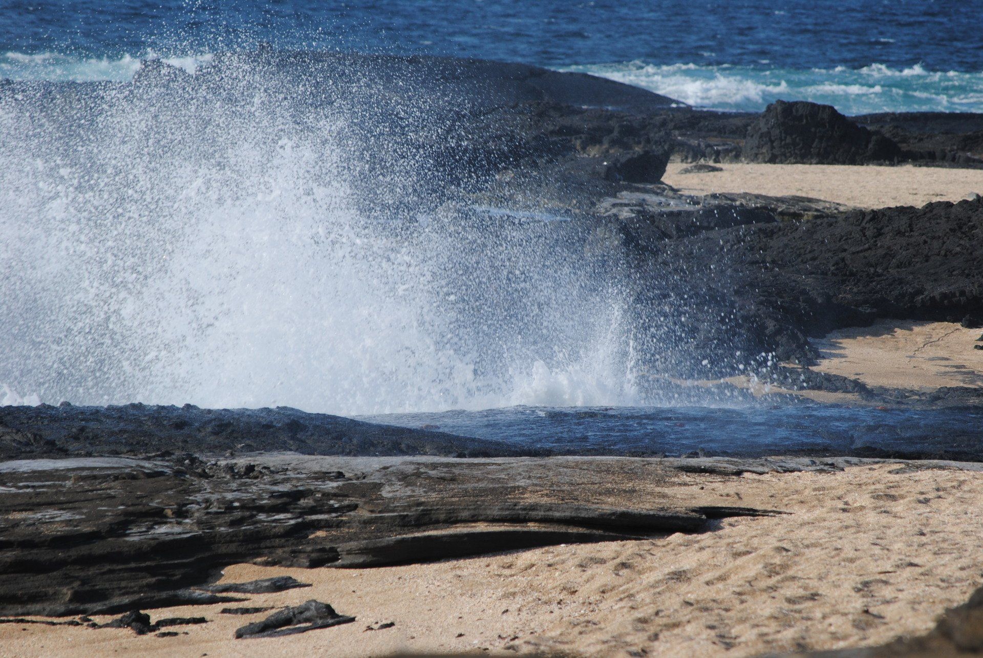 Waves crashing against a rocky shoreline on a beach