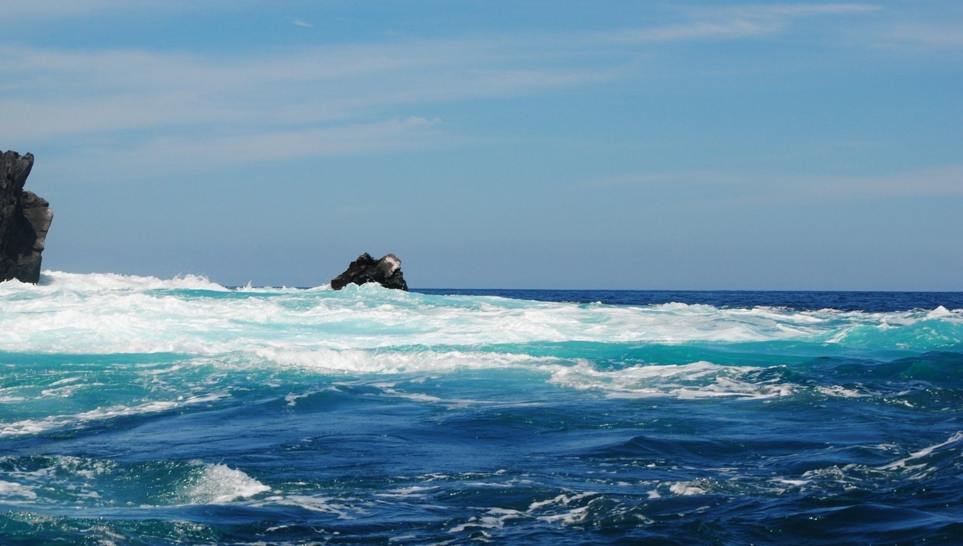 A large rock in the middle of the ocean