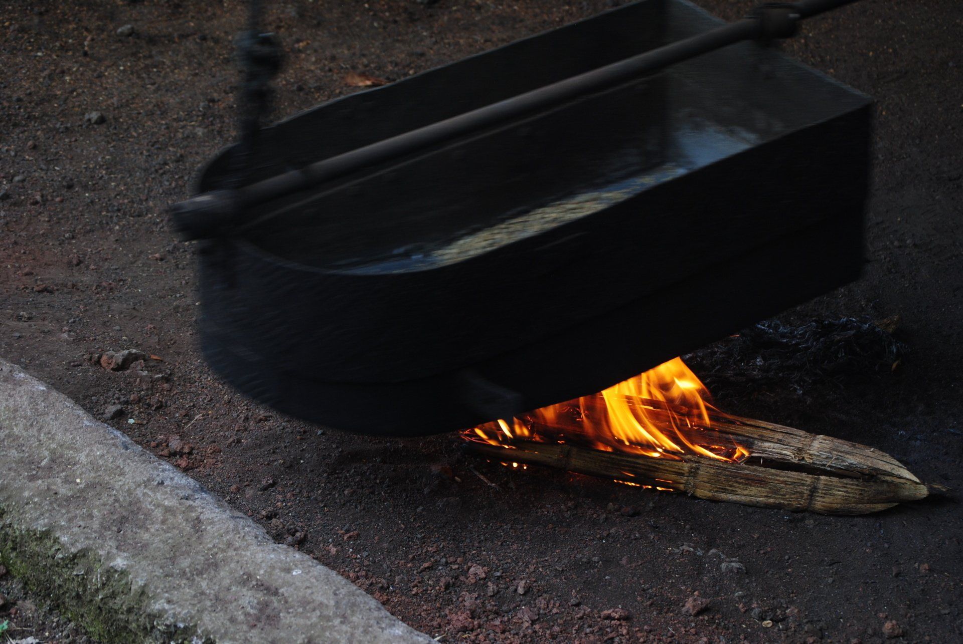 A pot of water is cooking over a fire.