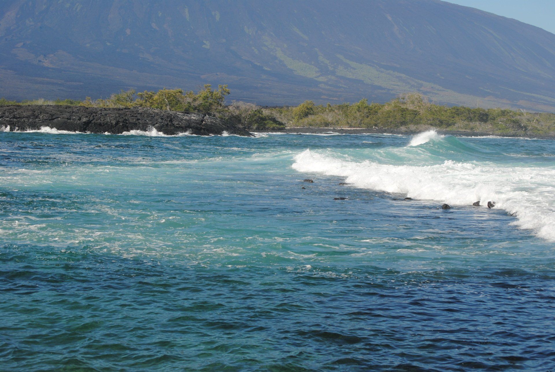 A large body of water with a mountain in the background.