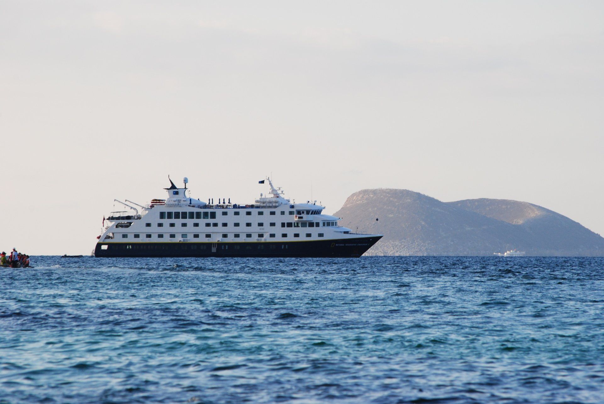 A large cruise ship is floating on top of a large body of water.