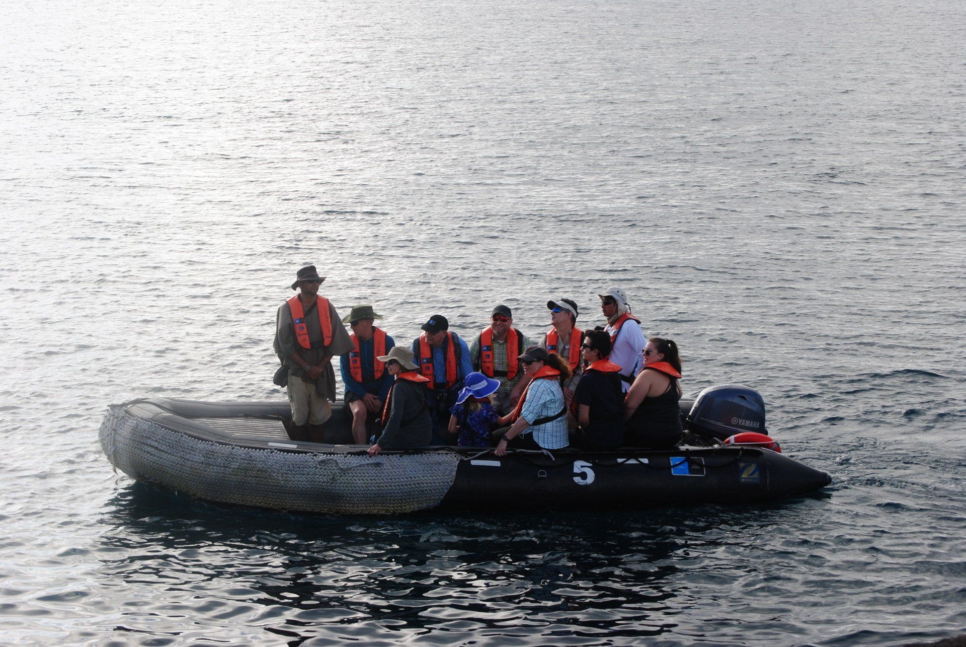 A group of people in a boat with the number 5 on it