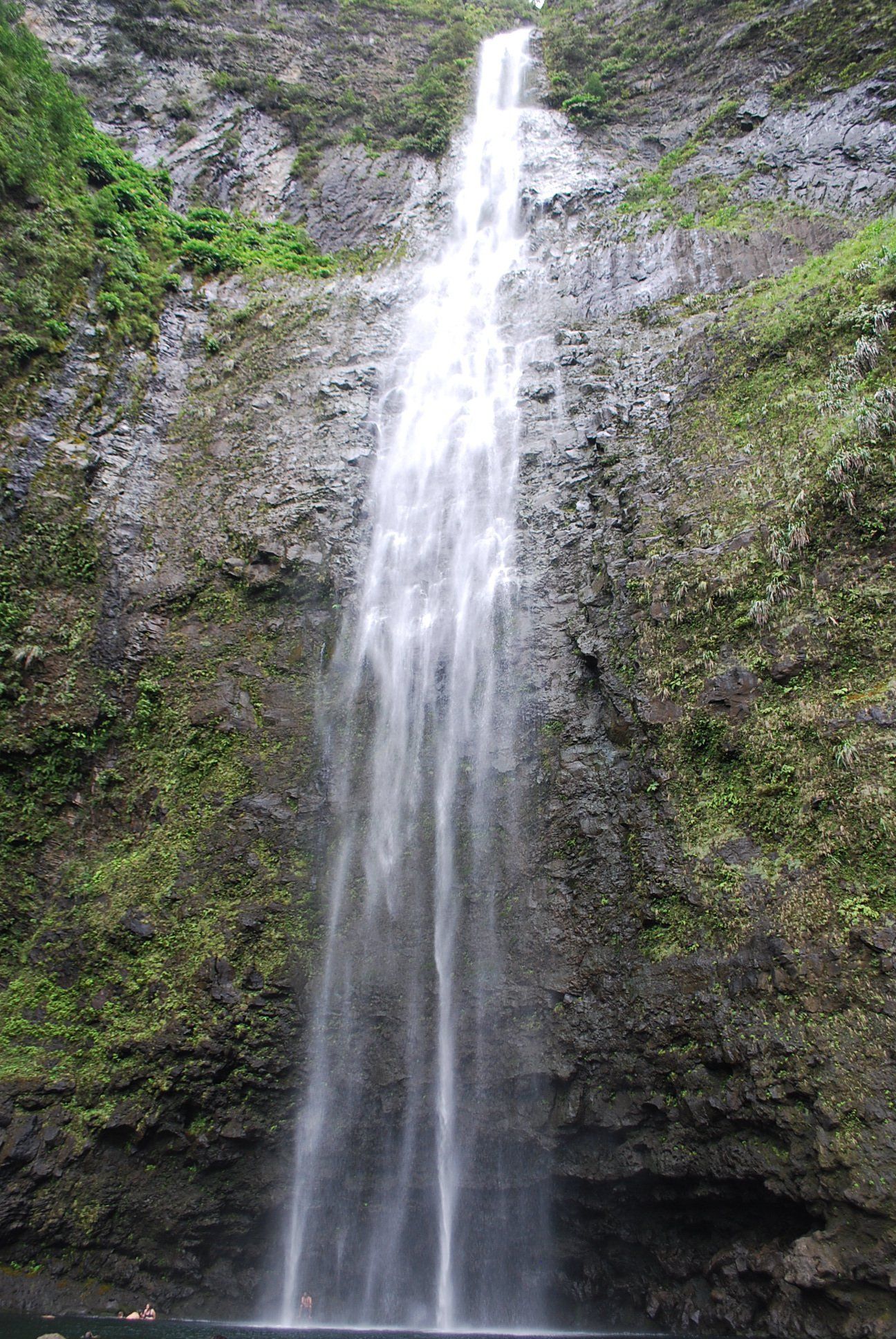 A waterfall is falling down a cliff into a body of water.
