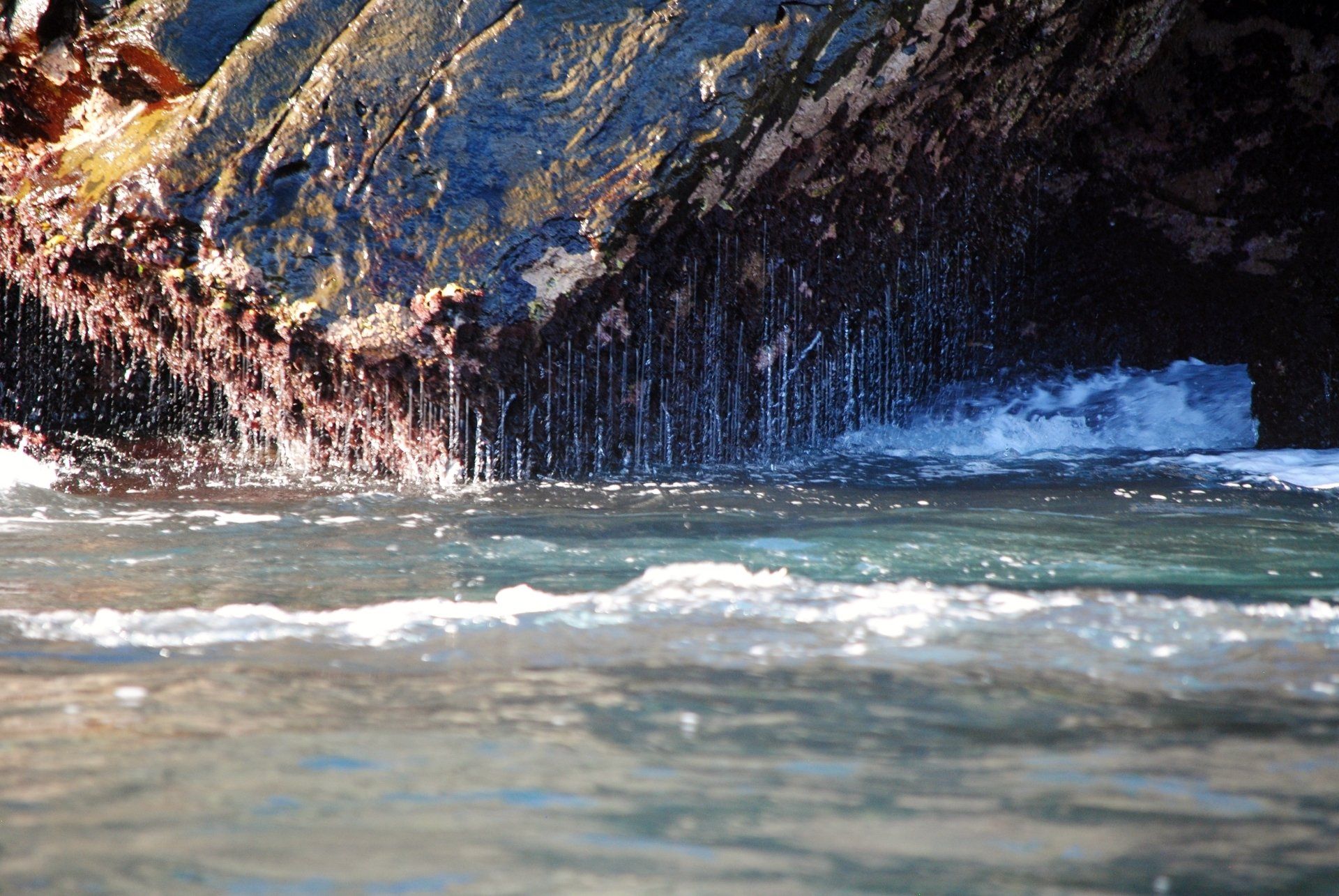 A close up of a body of water with a rock in the background