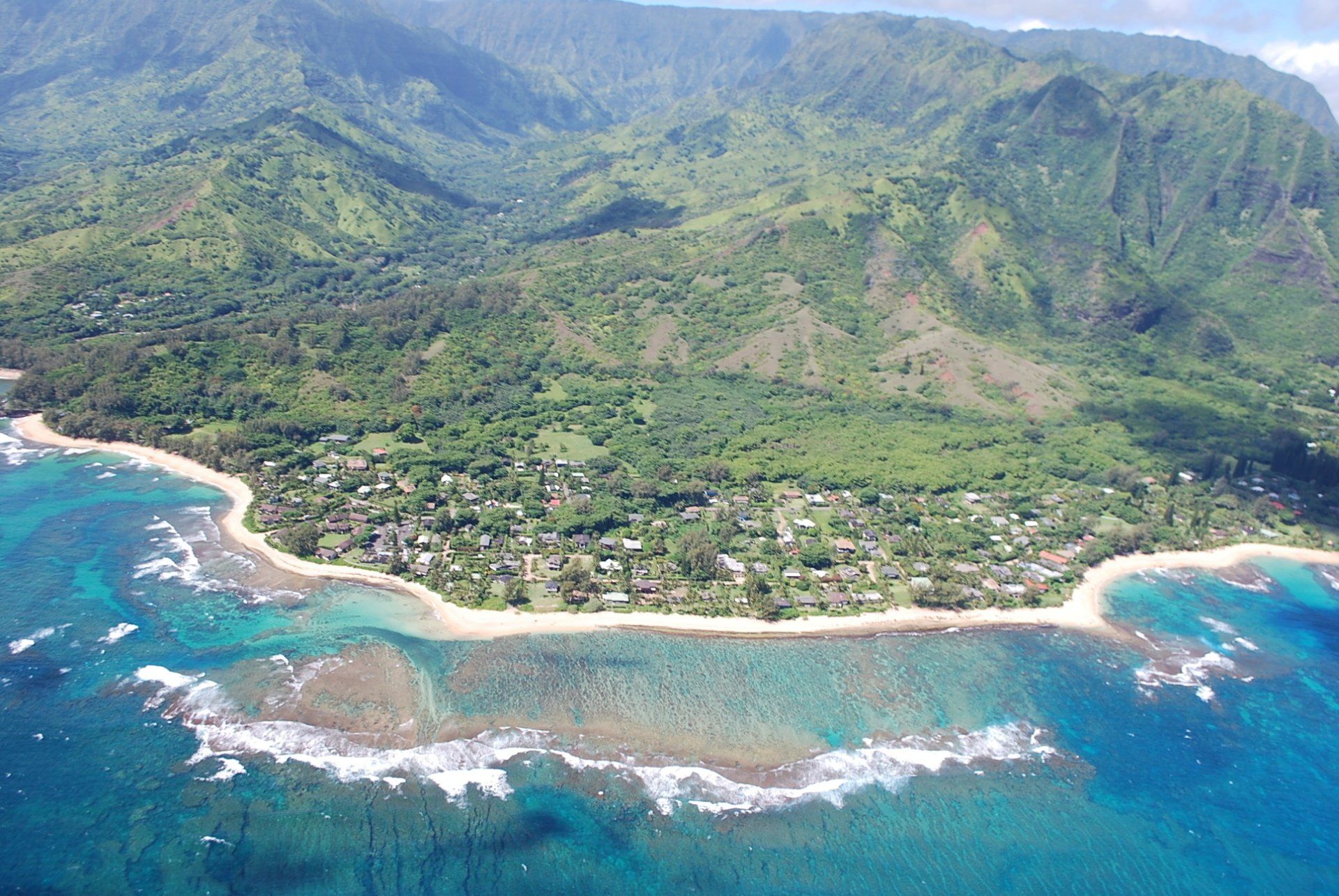 An aerial view of a beach with mountains in the background