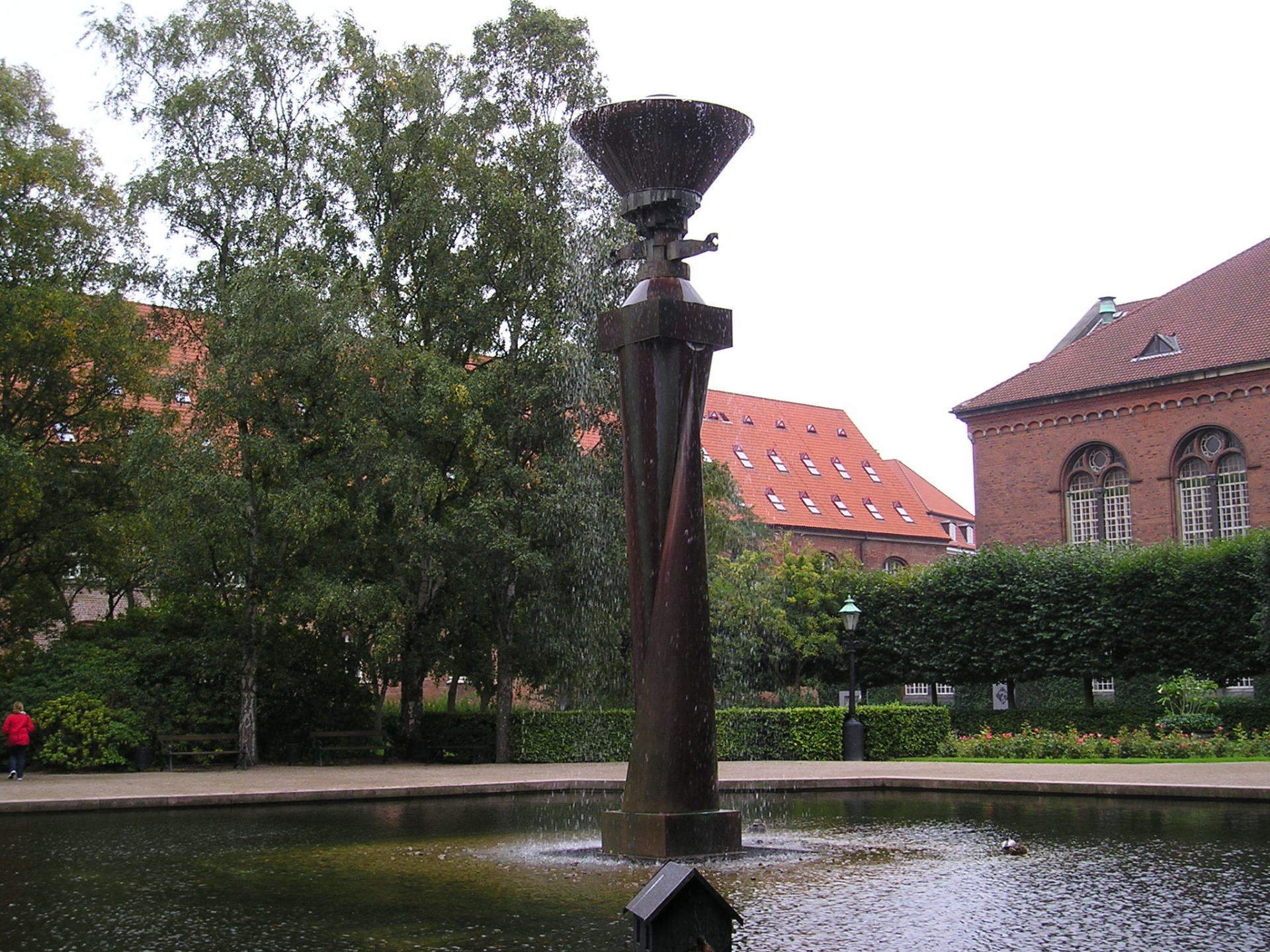 A fountain in a park with a building in the background