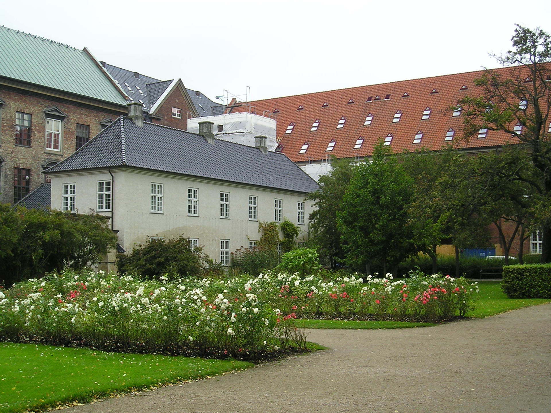 A white building with a roof that has a lot of windows