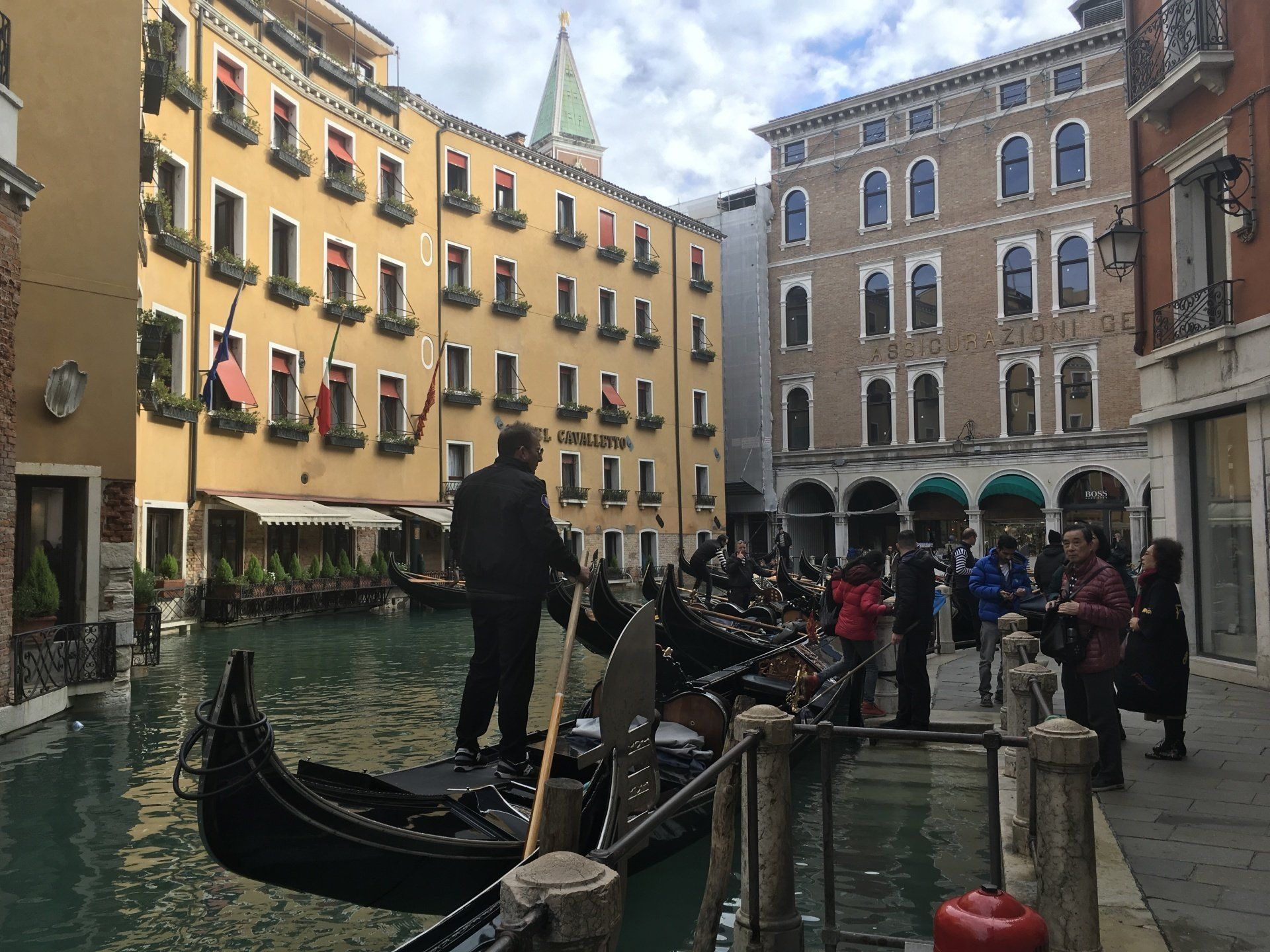 A man is riding a gondola down a canal in venice.