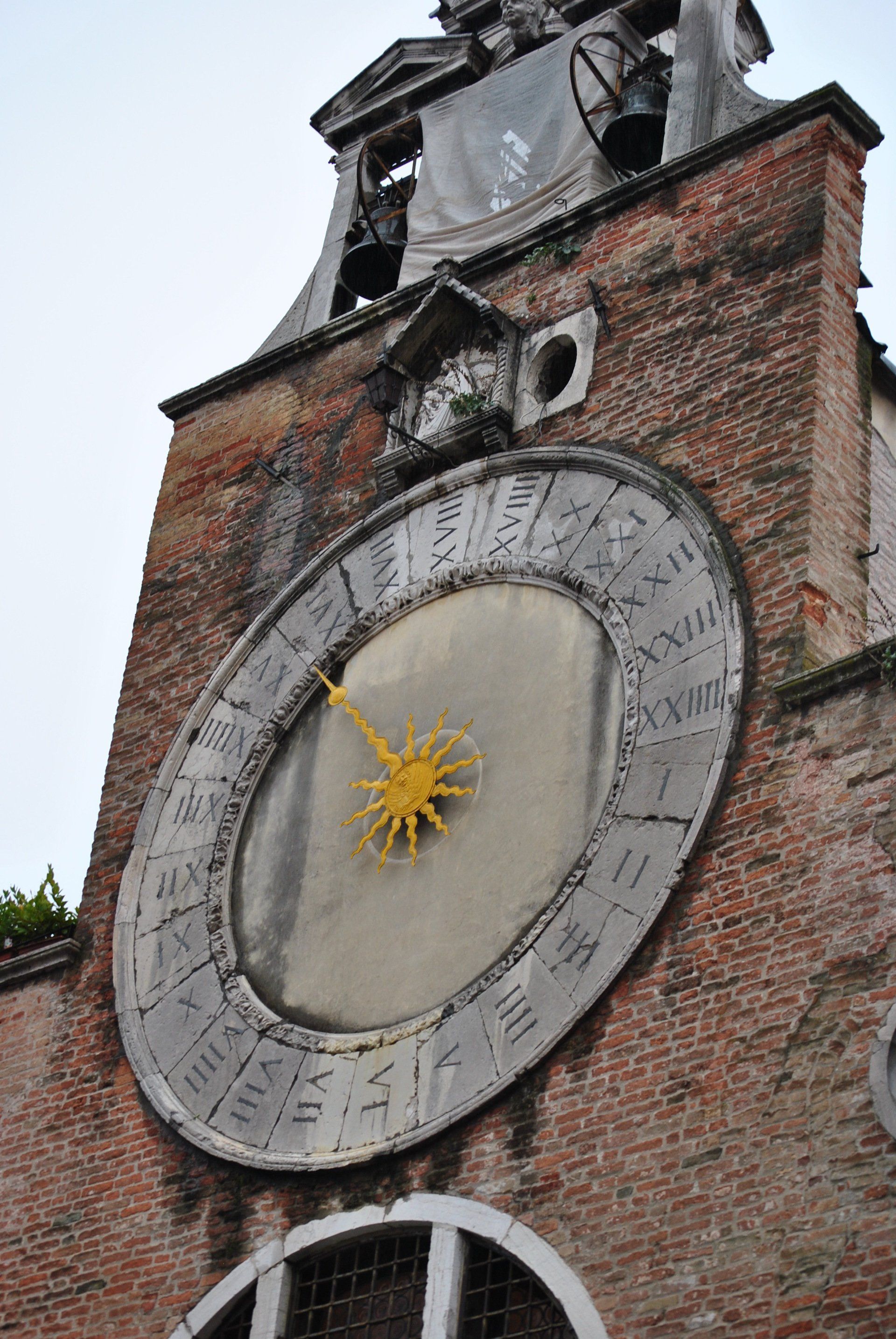 A large clock on top of a brick building shows the time as 4:20