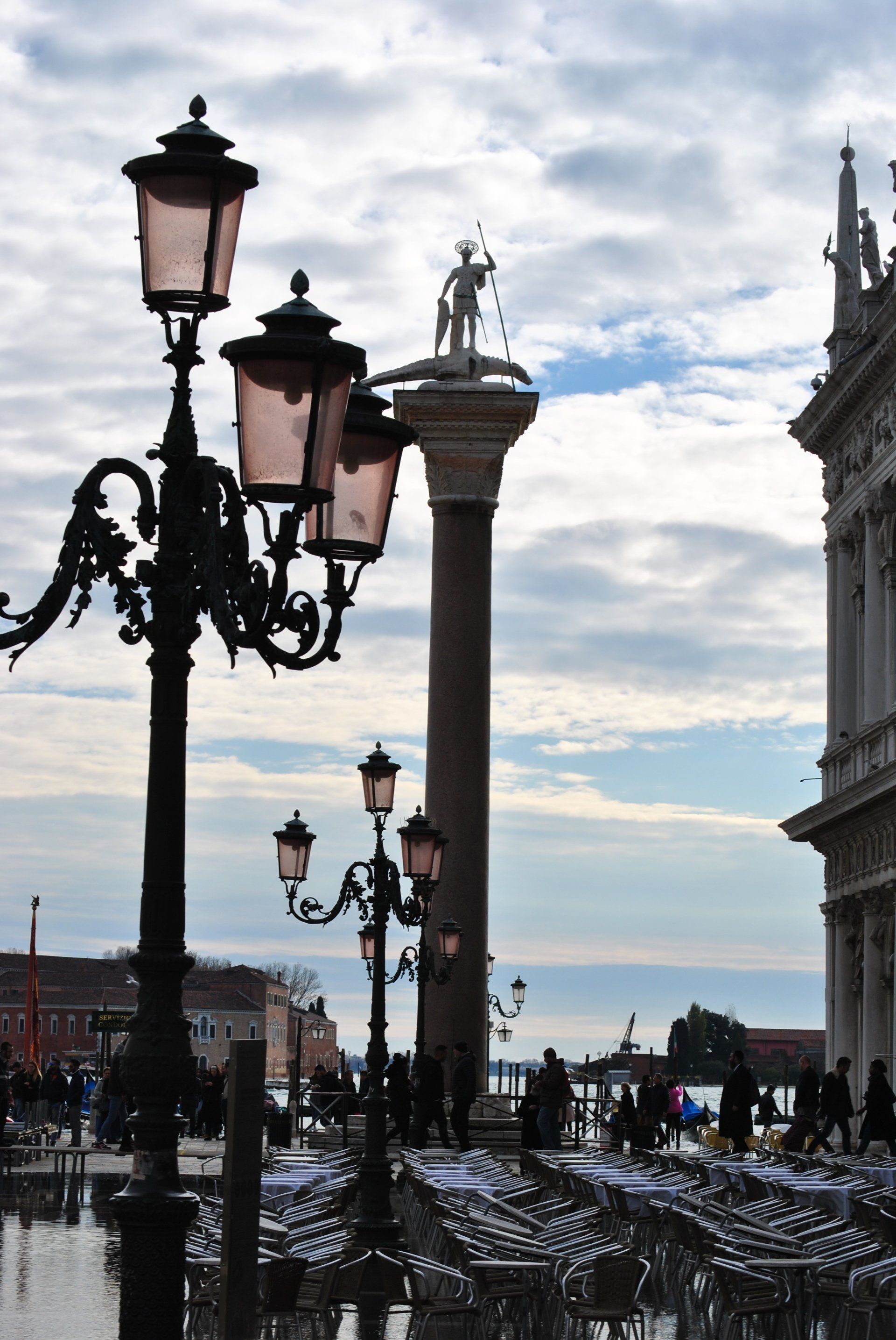 A row of street lights are lined up in front of a building