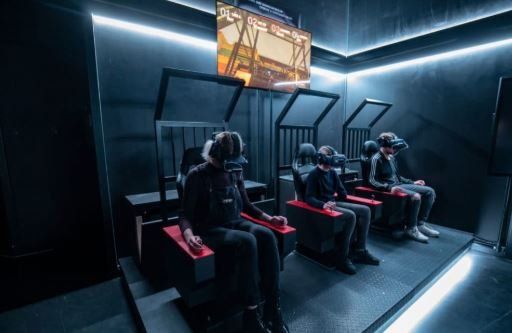 A group of people are sitting in chairs wearing virtual reality headsets.