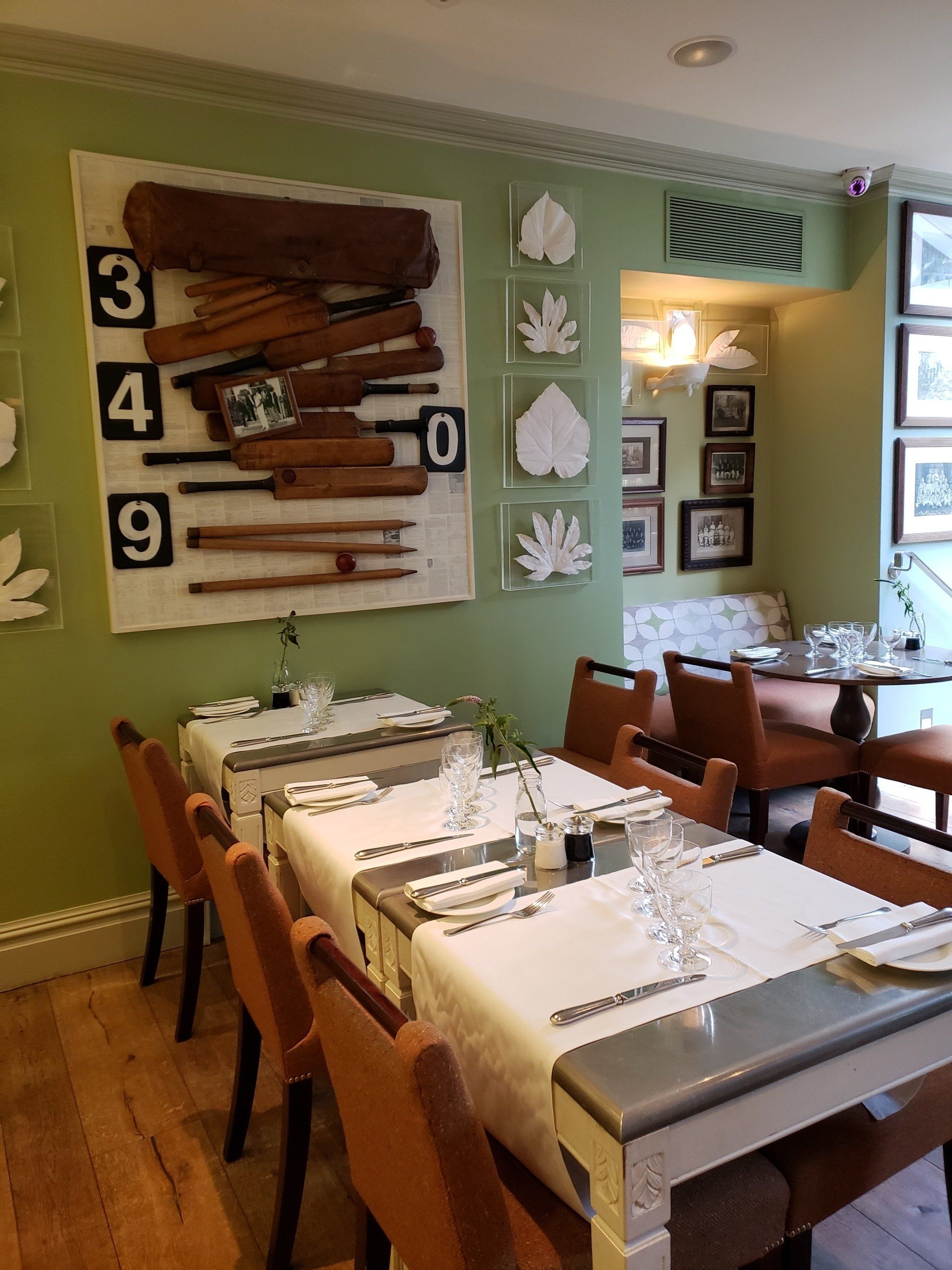 A dining room with tables and chairs and a green wall