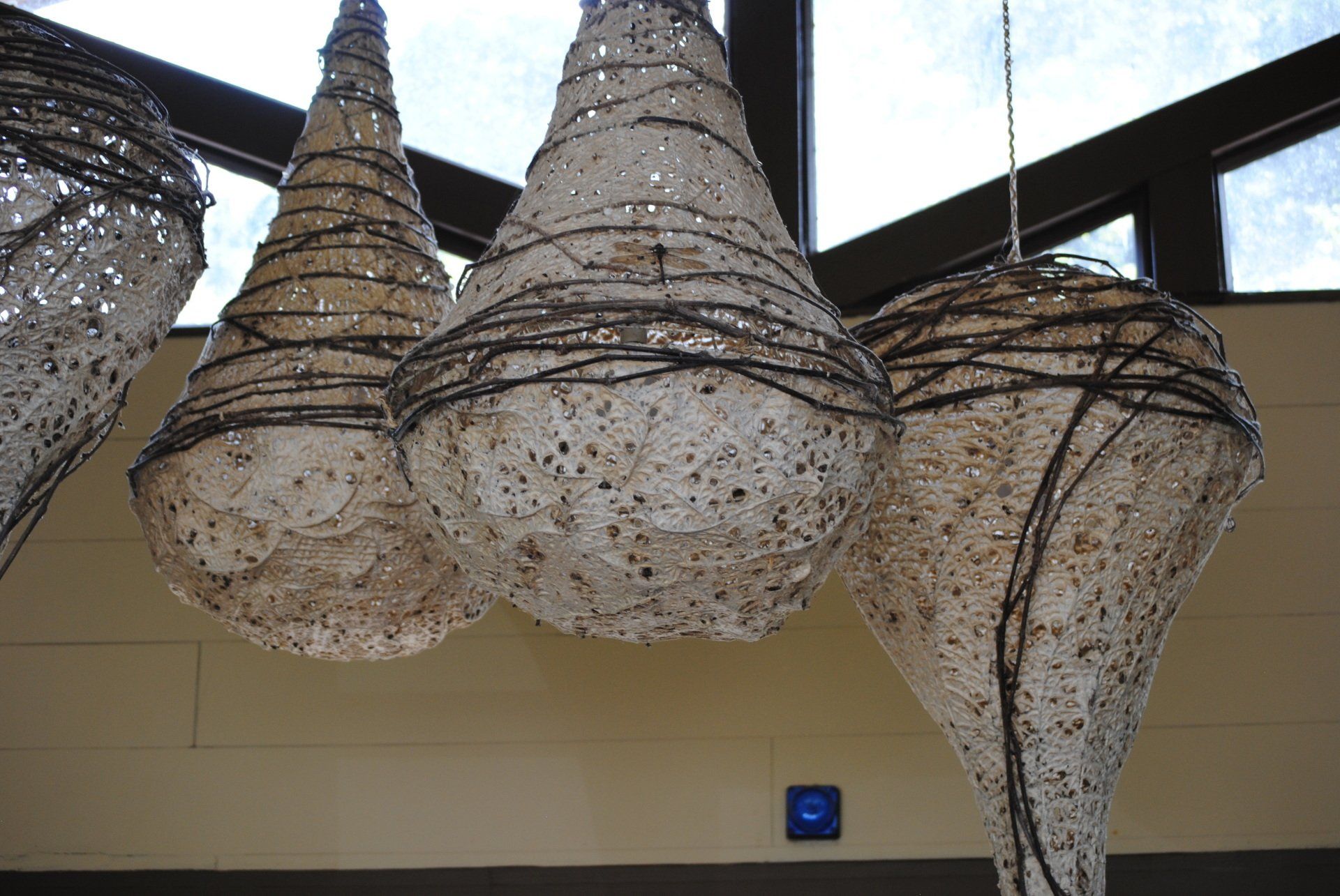 A group of sculptures hanging from the ceiling in a room.