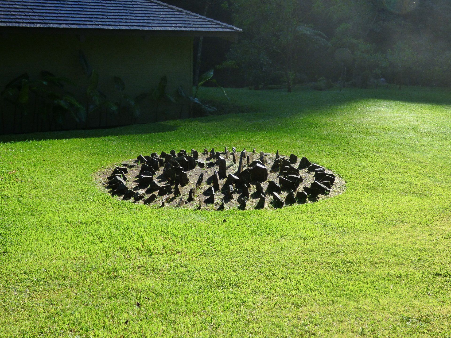 A large hole in the grass in front of a house.