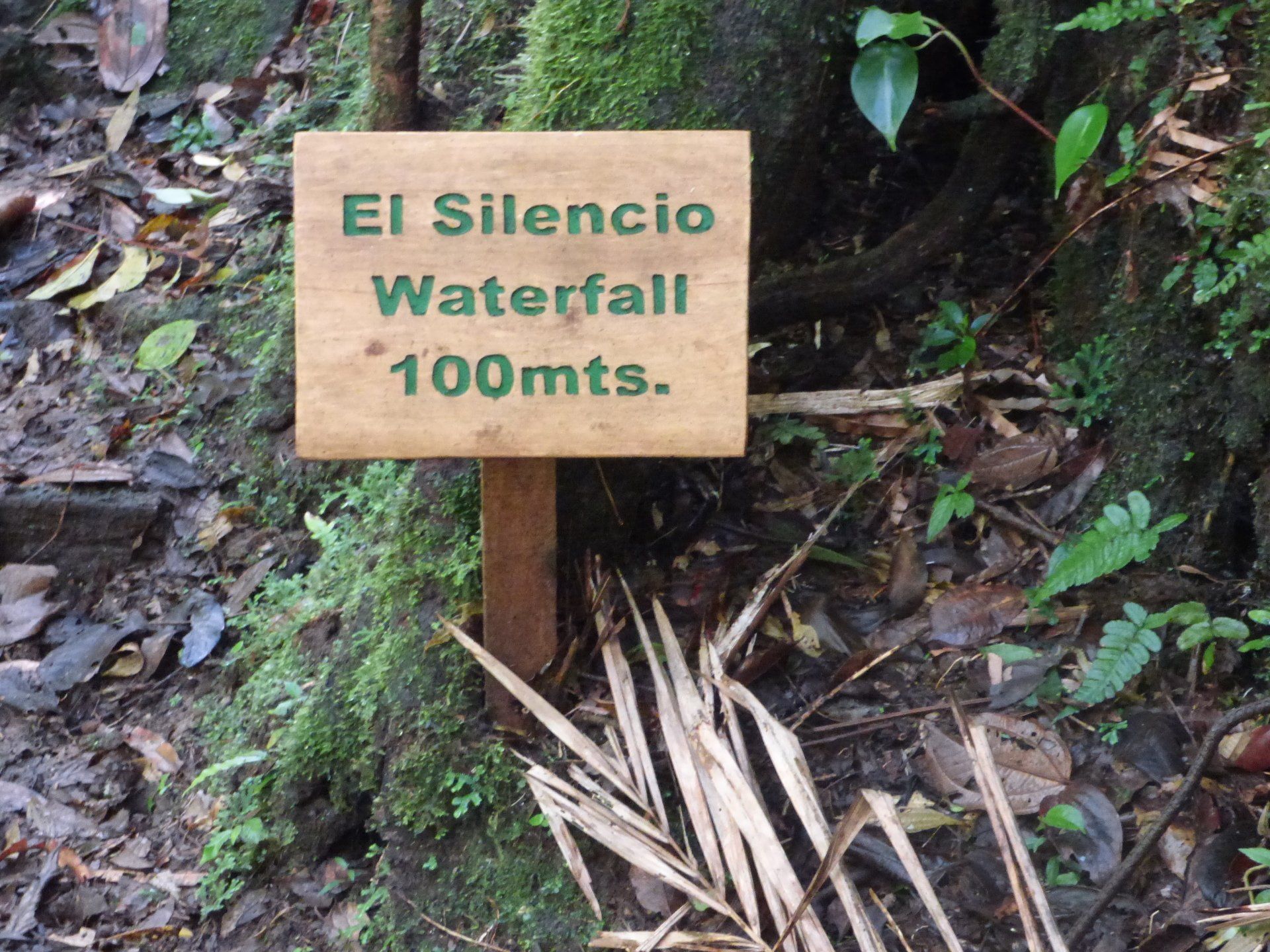 A wooden sign says el silencio waterfall 100 meters