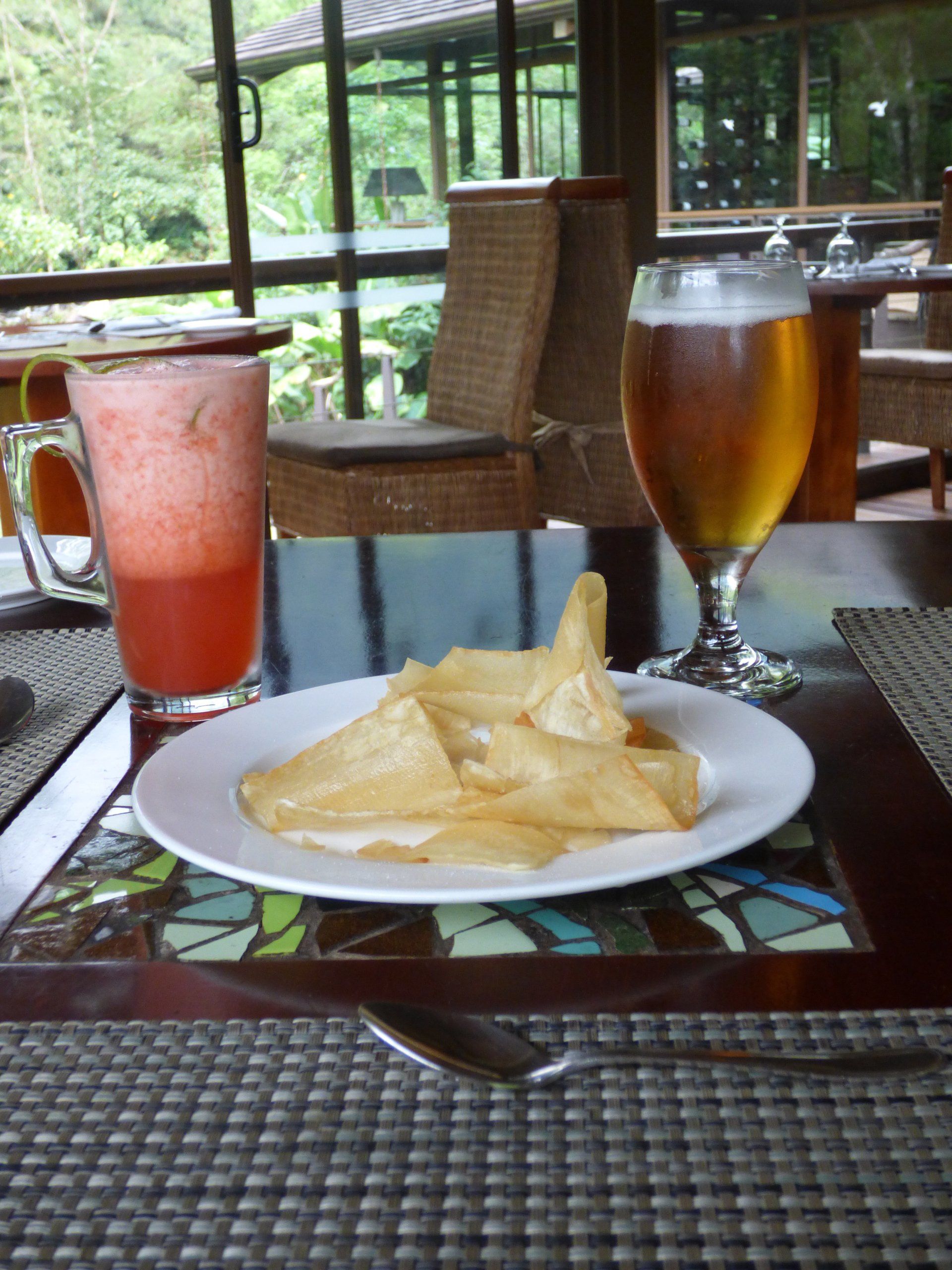 A plate of food and a glass of beer on a table
