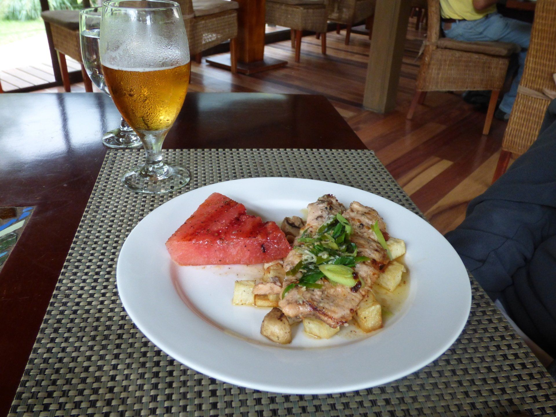 A plate of food and a glass of beer on a table