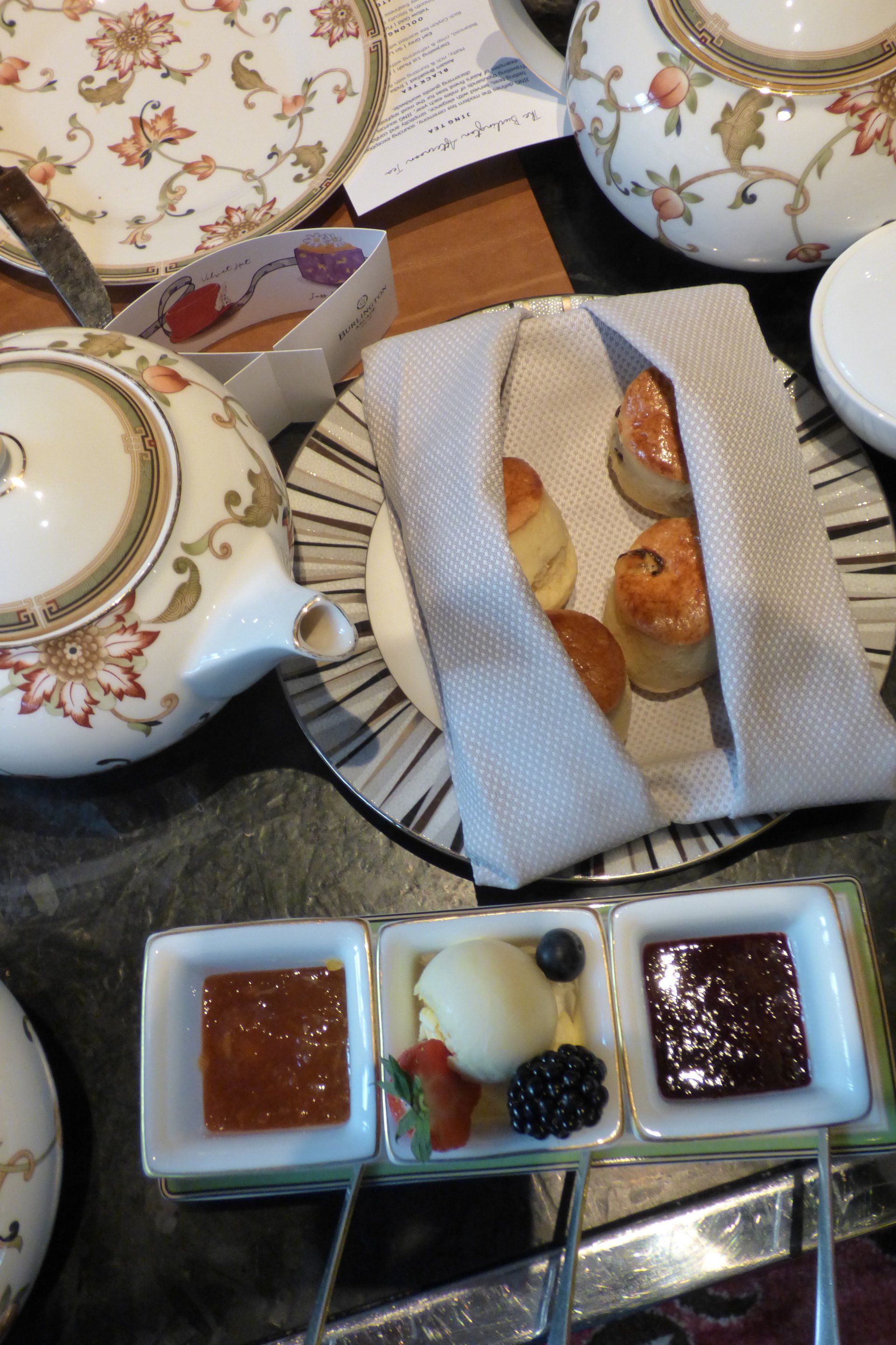 A table topped with plates of food and a teapot