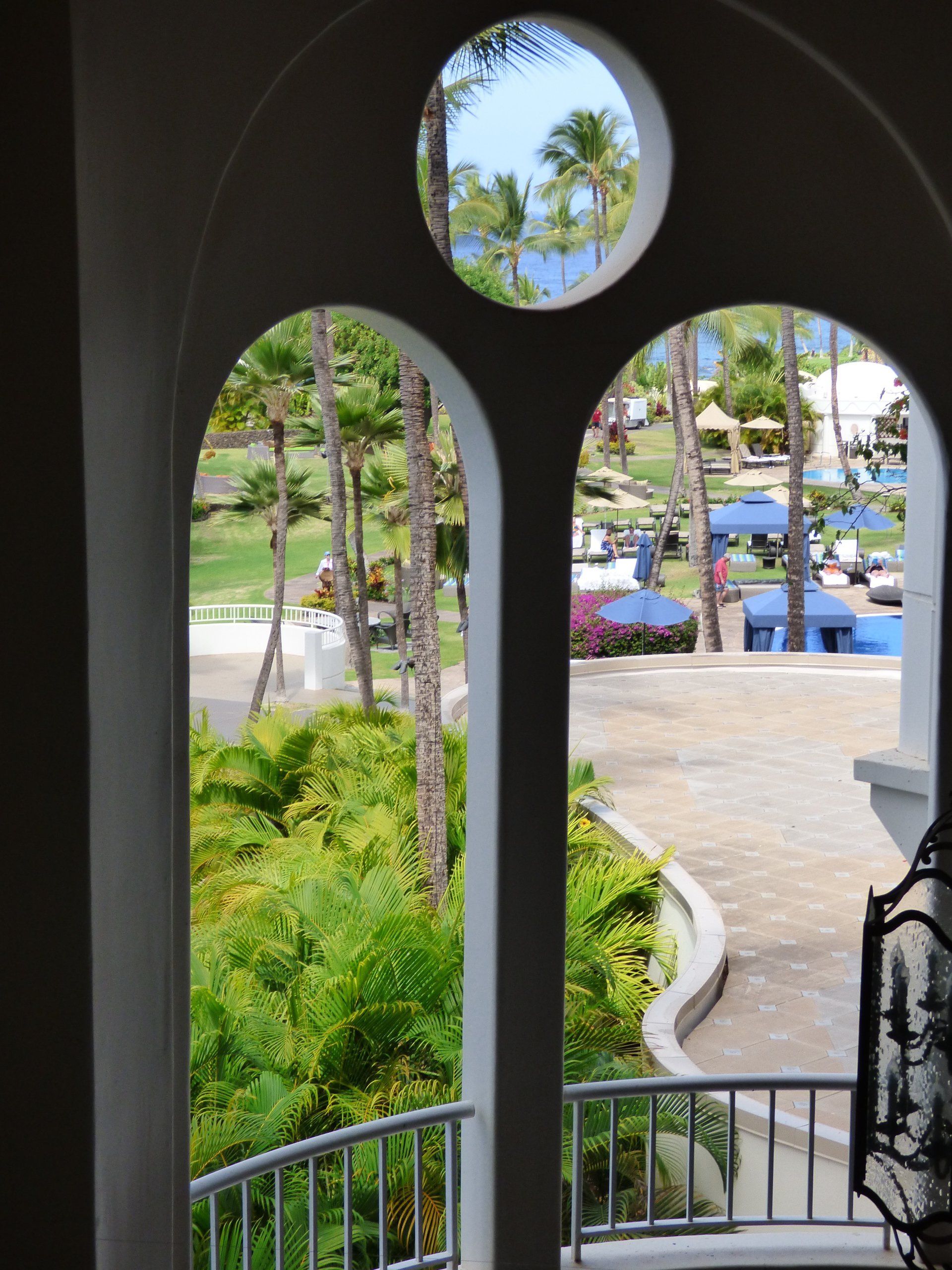 A view of a park through a window with arches