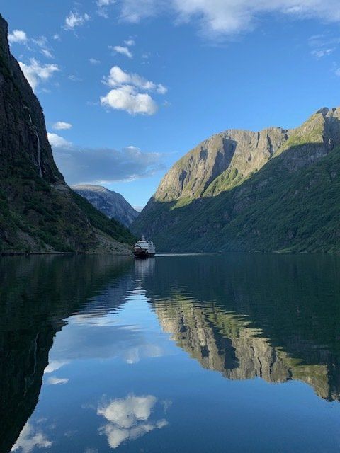 A boat is floating on a lake with mountains in the background