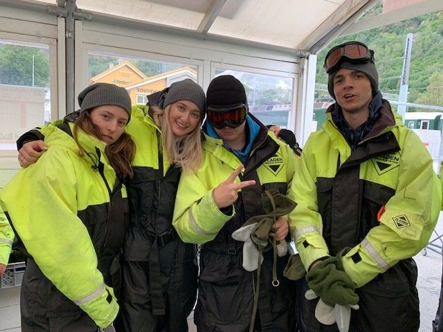 A group of people wearing yellow and black jackets and goggles are posing for a picture.