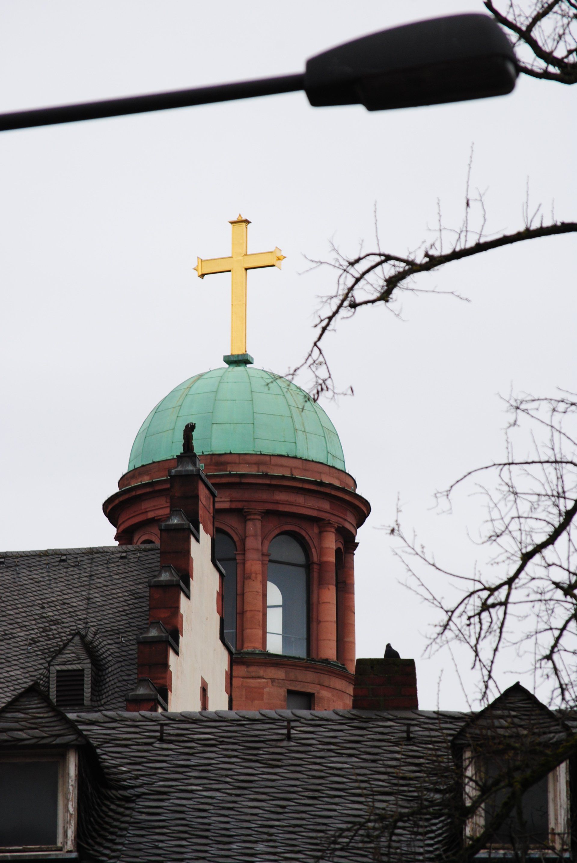 A green dome with a cross on top of it