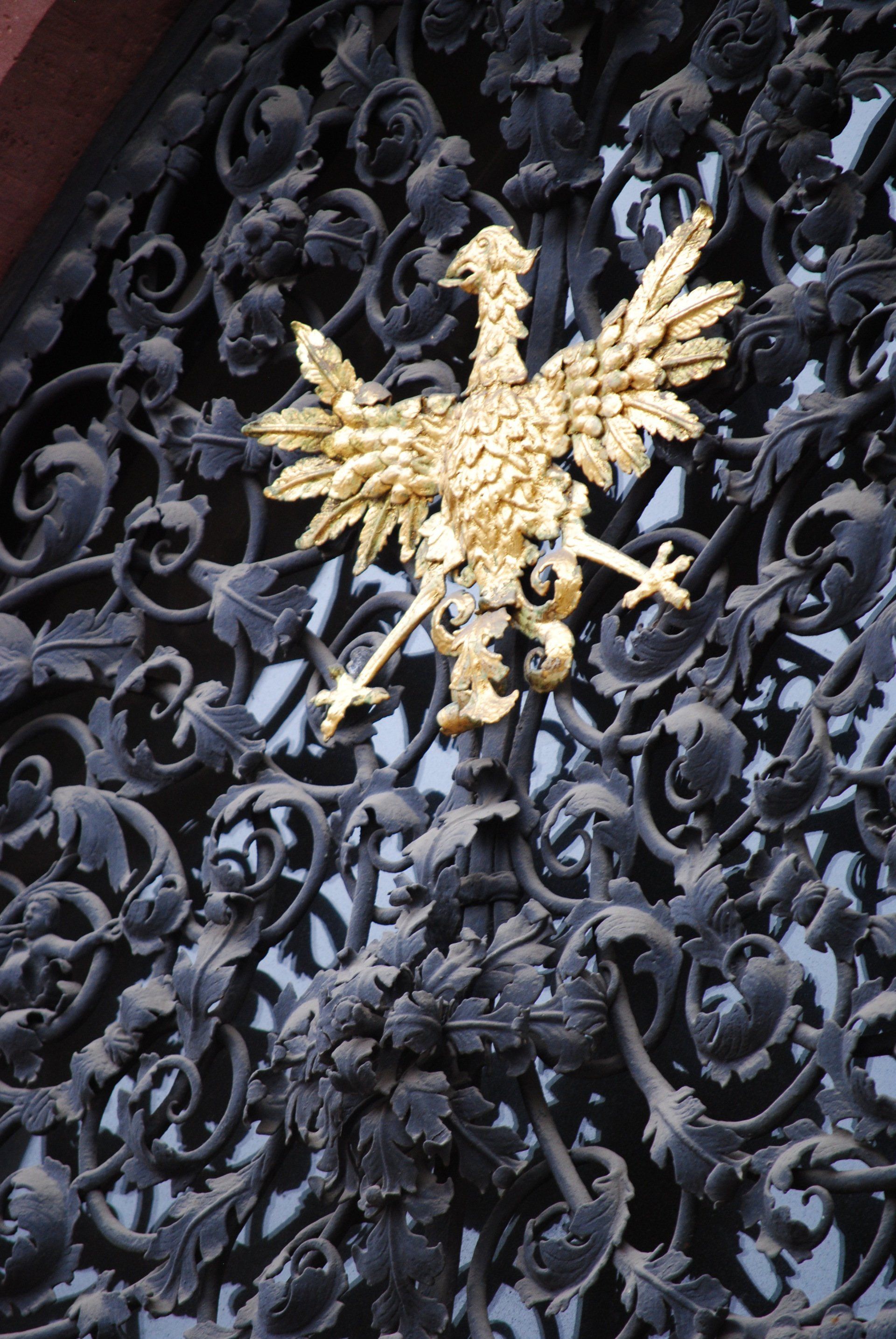 A close up of a wrought iron gate with a gold eagle on it