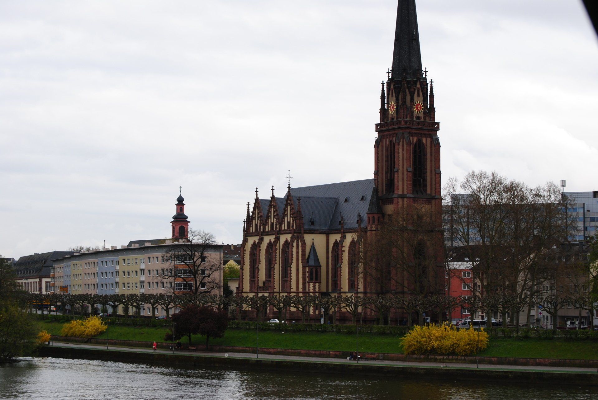 A large building with a clock tower is next to a body of water