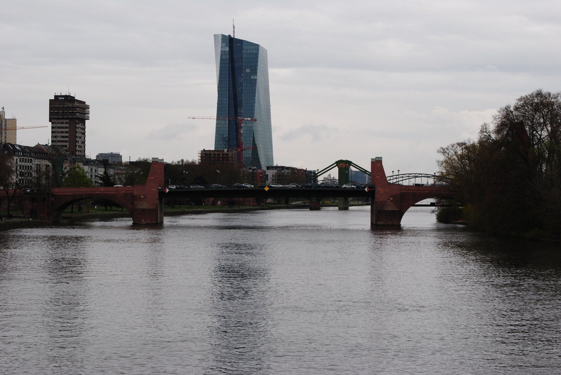A bridge over a river with a skyscraper in the background