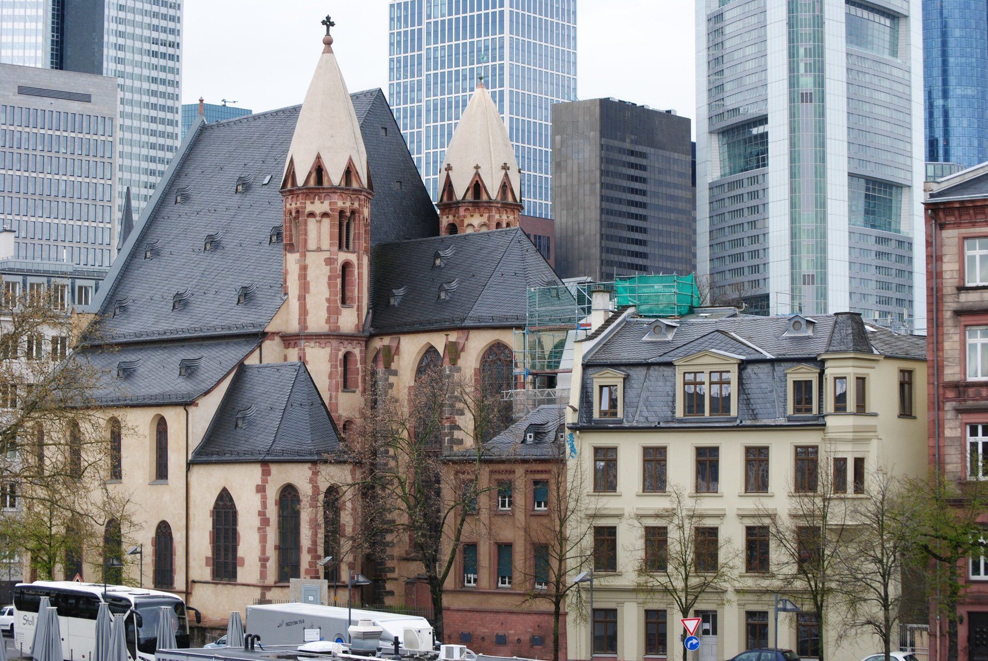 A church is surrounded by tall buildings in a city
