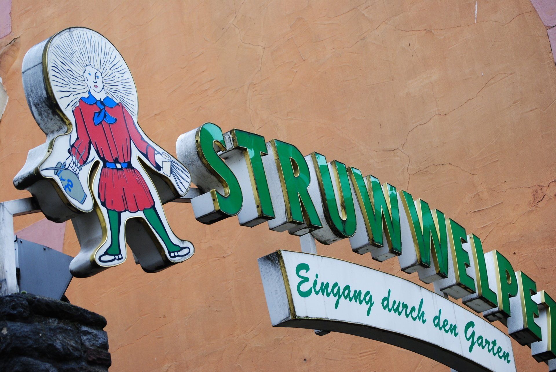 A sign that says ' eingang durch den garten ' on it