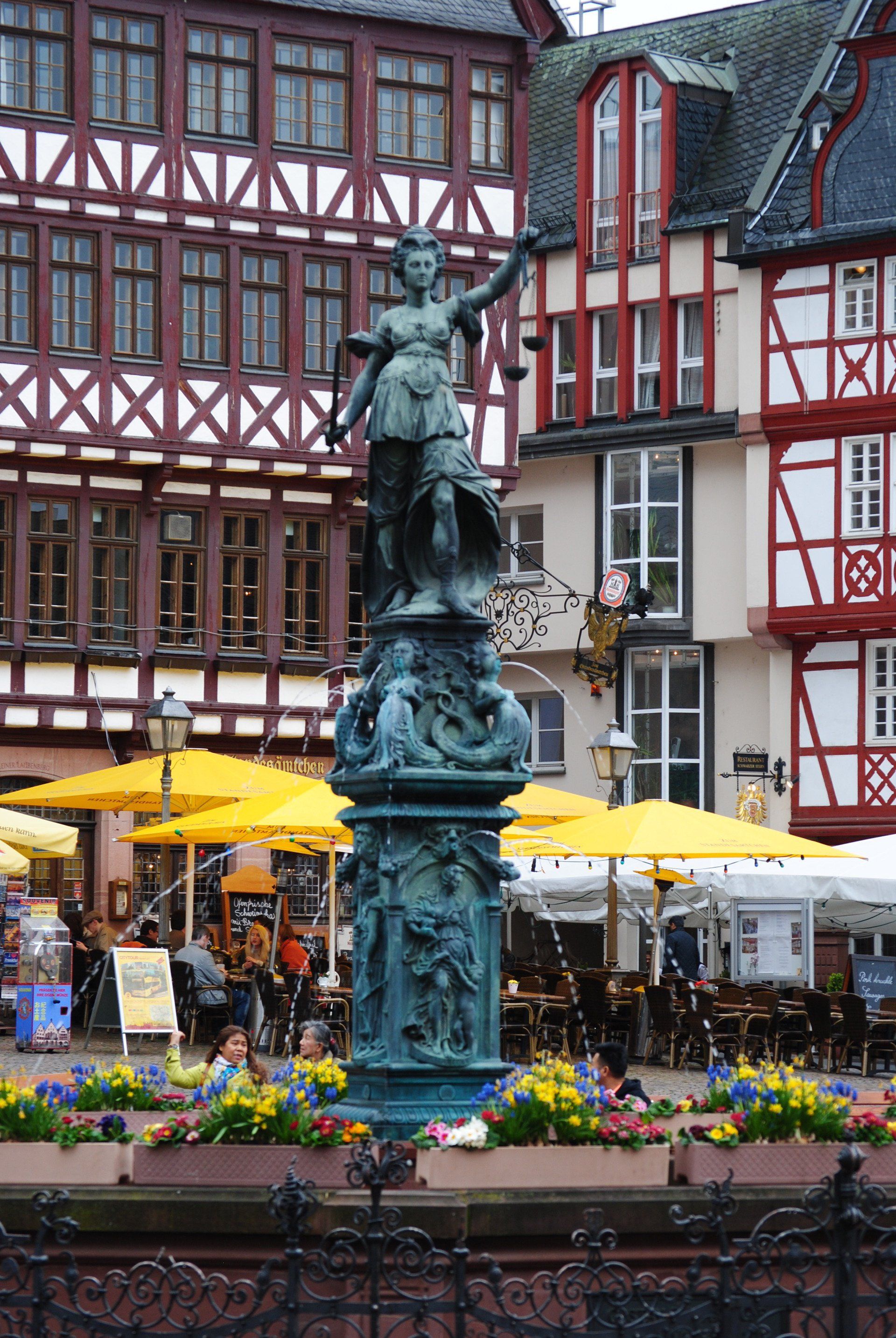 A statue of a woman stands in front of a building