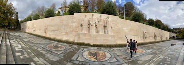 A group of people standing in front of a large wall.