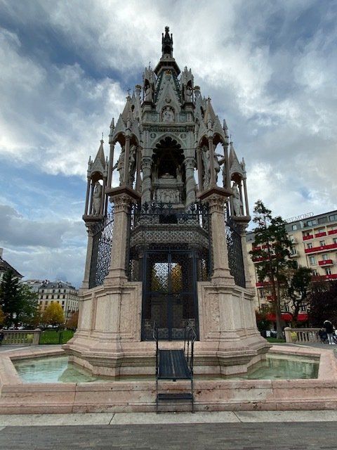 A large statue with a fountain in front of it