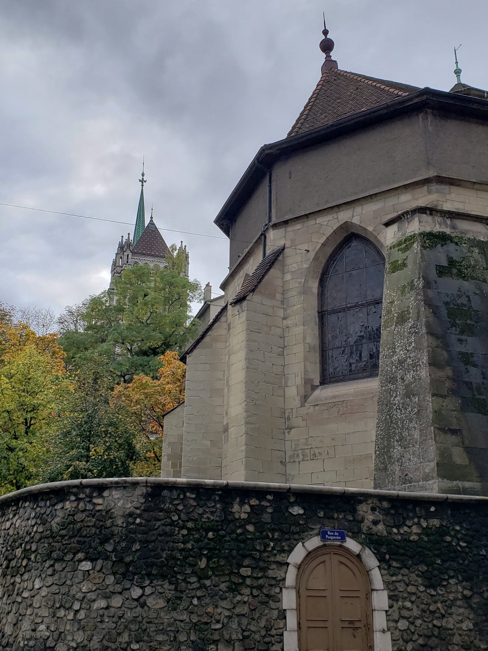 A church with a stone wall and a tower in the background