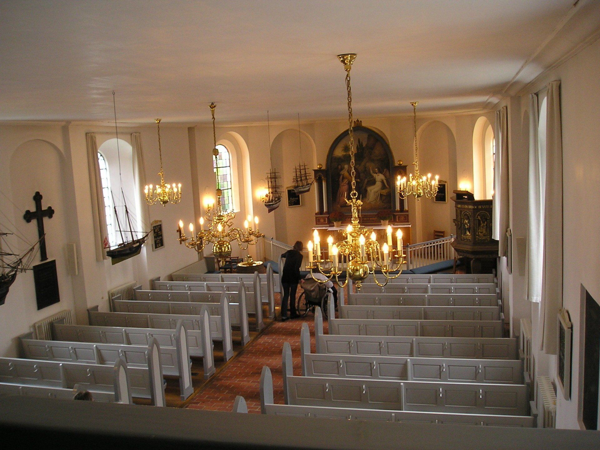 A church with rows of pews and a cross on the wall