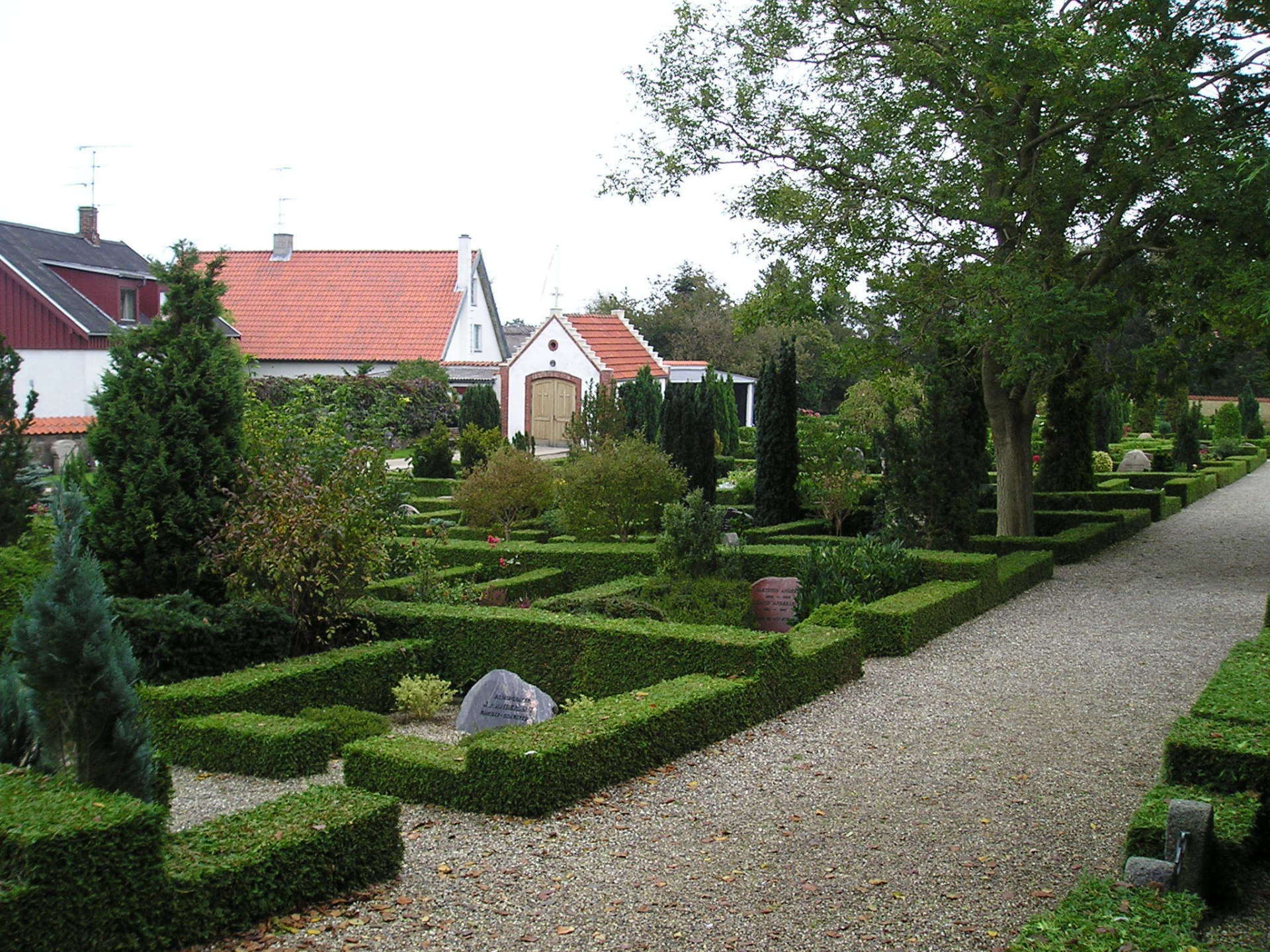 A gravel path leading to a house with a red roof