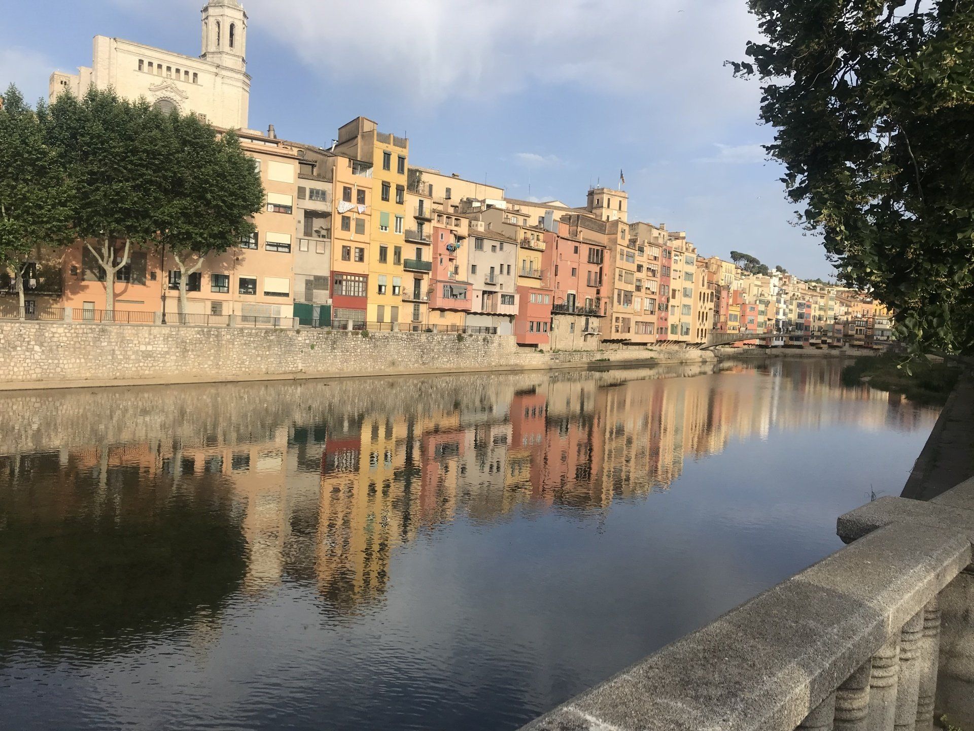 A river with a city in the background and buildings reflected in the water