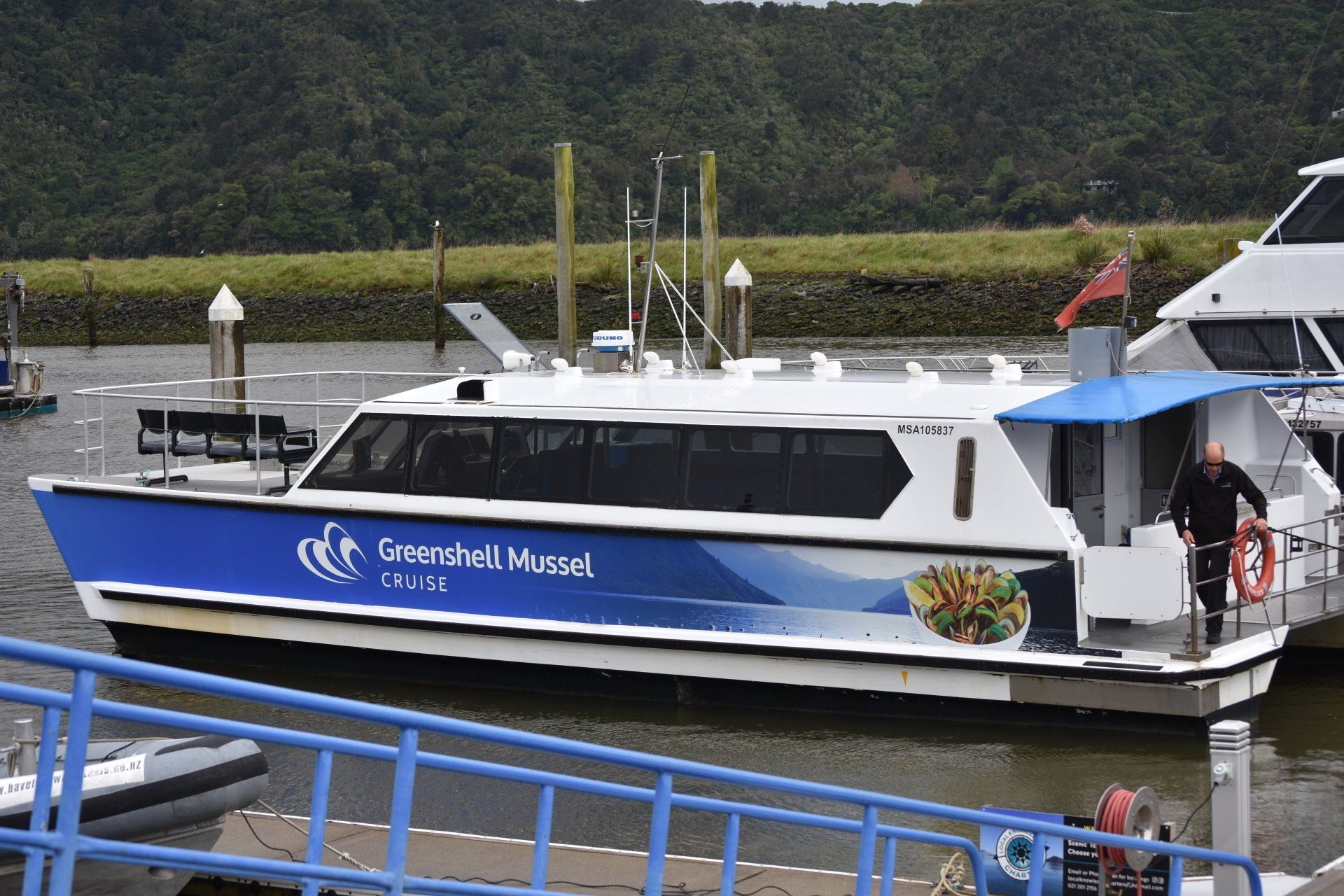 A large blue and white boat is docked at a dock.
