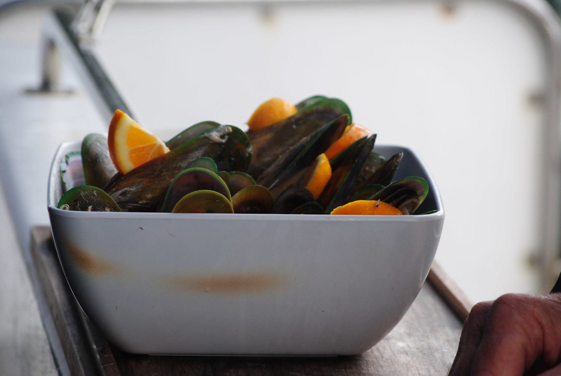 A person is holding a bowl of food on a table.