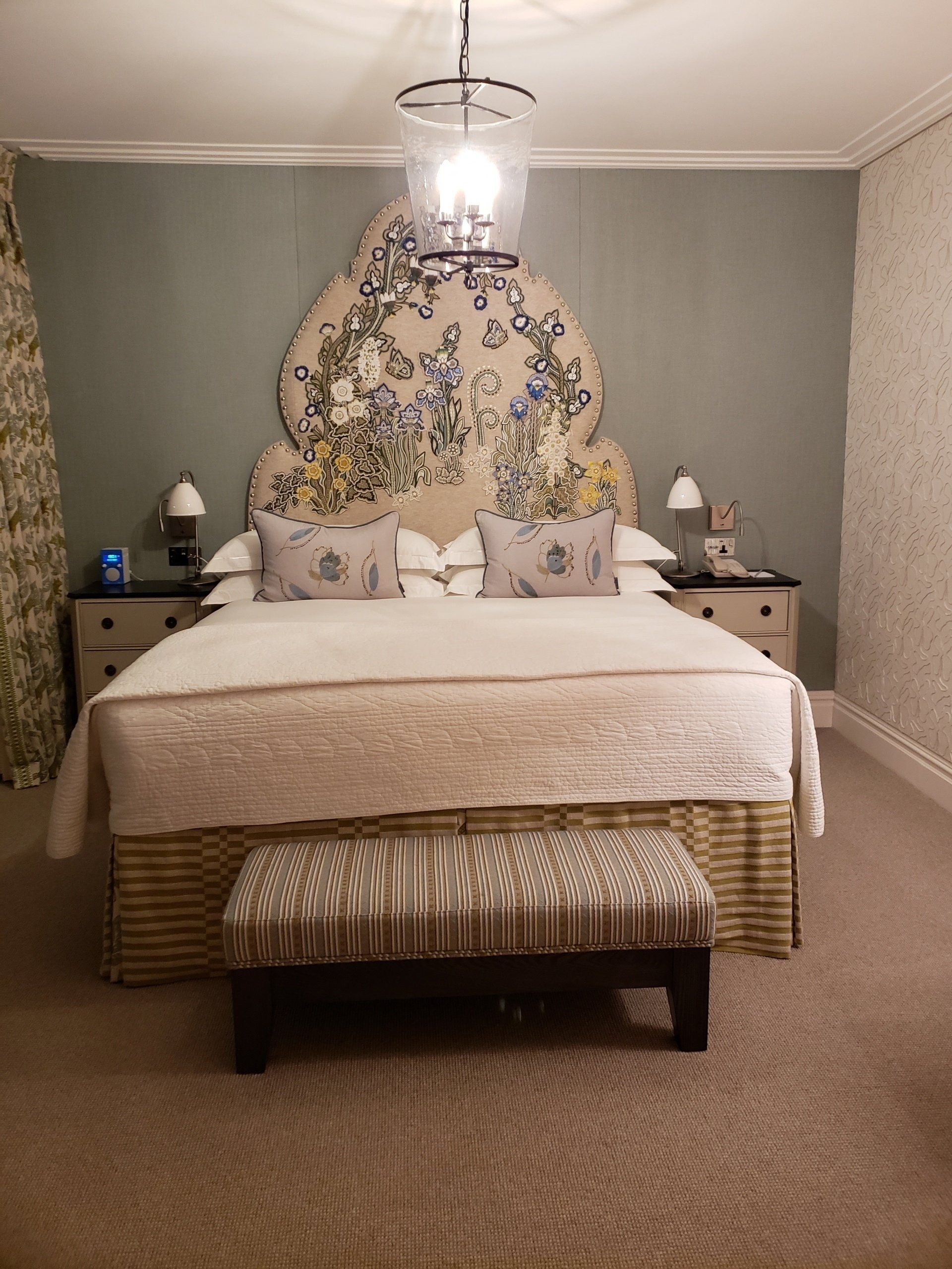 A bedroom with a large bed and a bench in front of it.