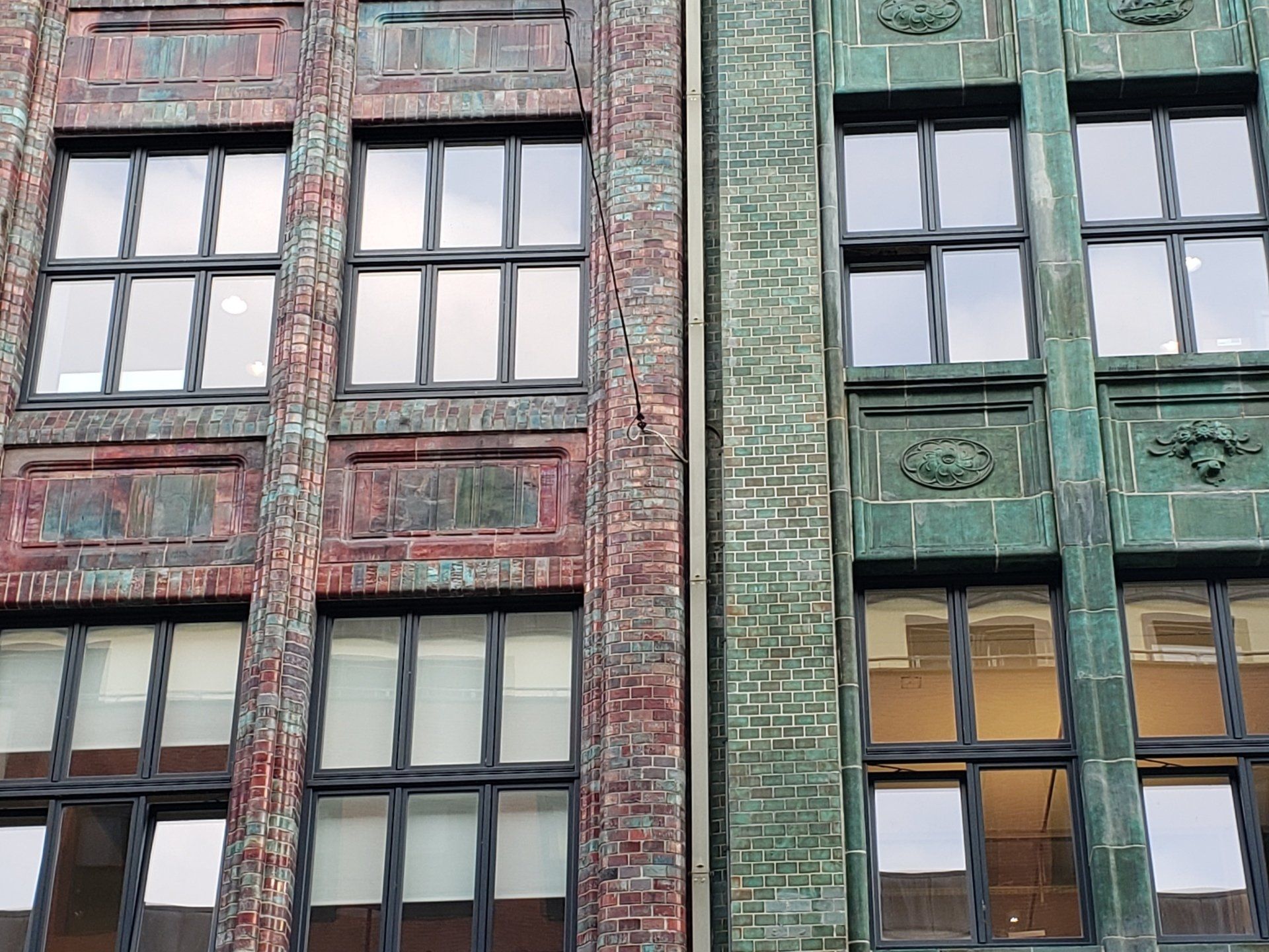 A brick and green building with lots of windows